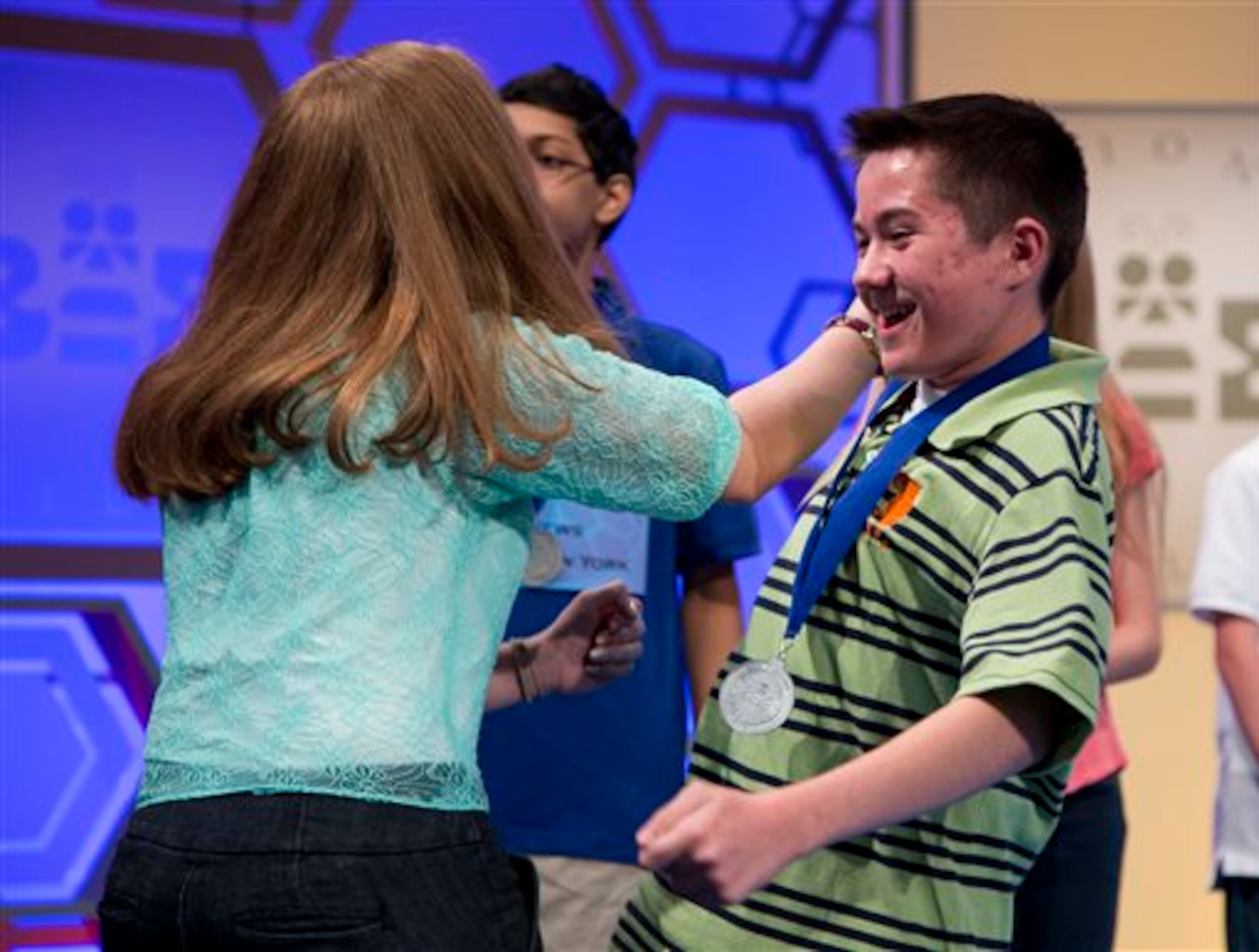 Caleb Miller, of Calhoun, La., right, gets a high-five from Emily Keaton, of Pikeville, Ken., left, after it was announced that they both made the semifinal round of the National Spelling Bee on Wednesday, May 29, 2013, in Oxon Hill, Md. (AP Photo/Evan Vucci)
