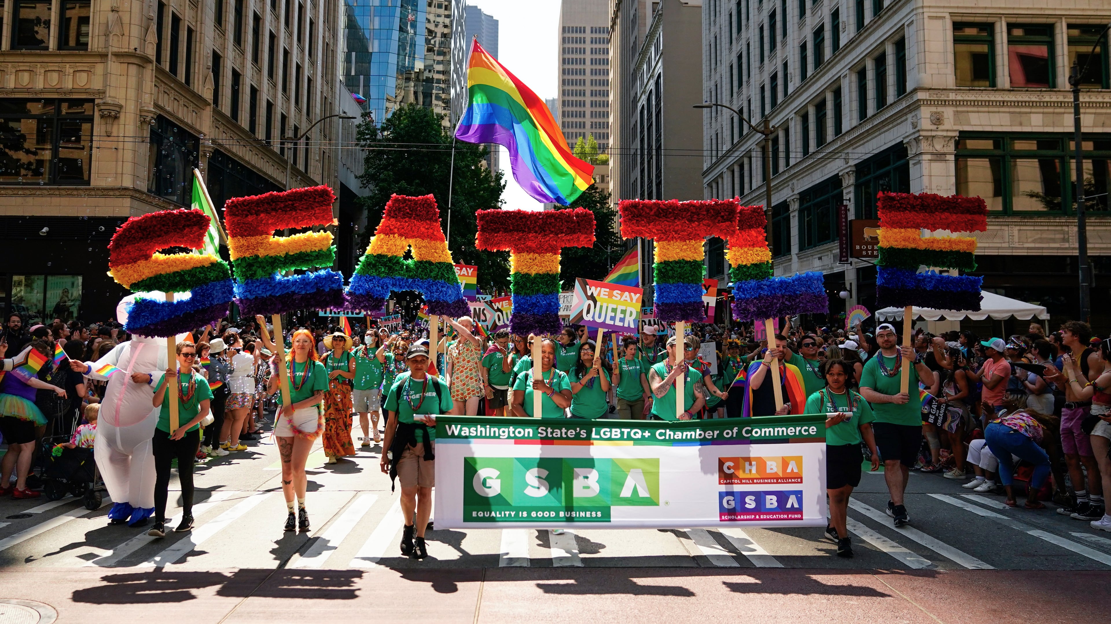 FILE - Marchers with the Greater Seattle Business Association, Washington State's LGBTQ+ and allied chamber of commerce, hold rainbow letters spelling out "Seattle," during the annual Seattle Pride Parade, June 25, 2023, in Seattle. (AP Photo/Lindsey Wasson, File)