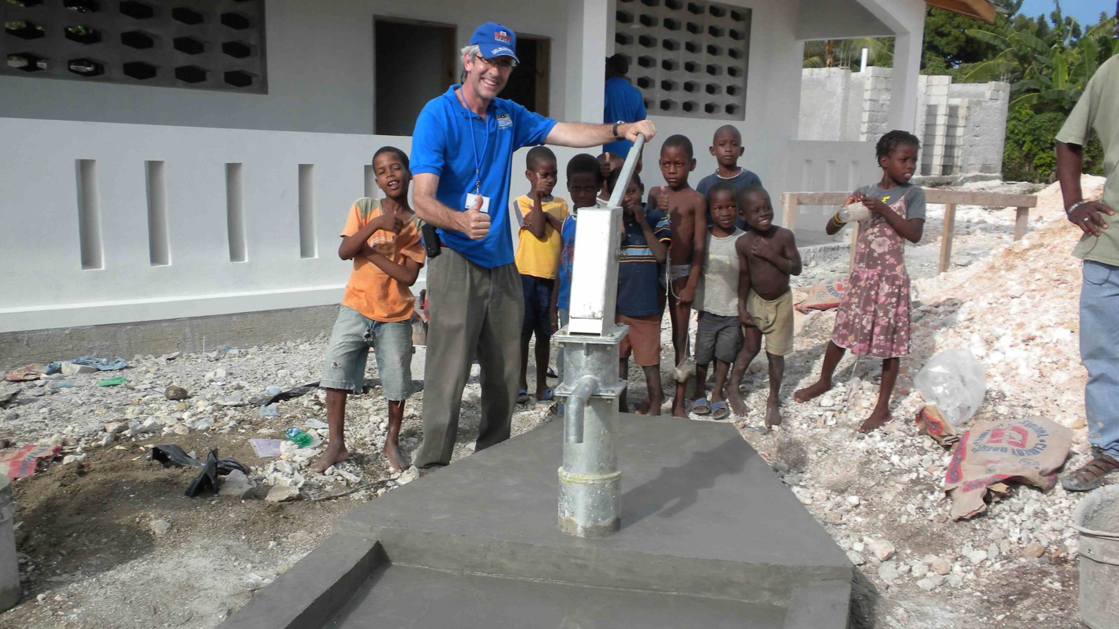 Civil rights attorney Ed Buckley has built more than 330 artesian wells and water reservoirs, providing water for nearly 350,000 people in Haiti since he founded the nonprofit Water Life Hope in 2005. He is pictured here with some of the region’s children at one of the newest wells. CONTRIBUTED