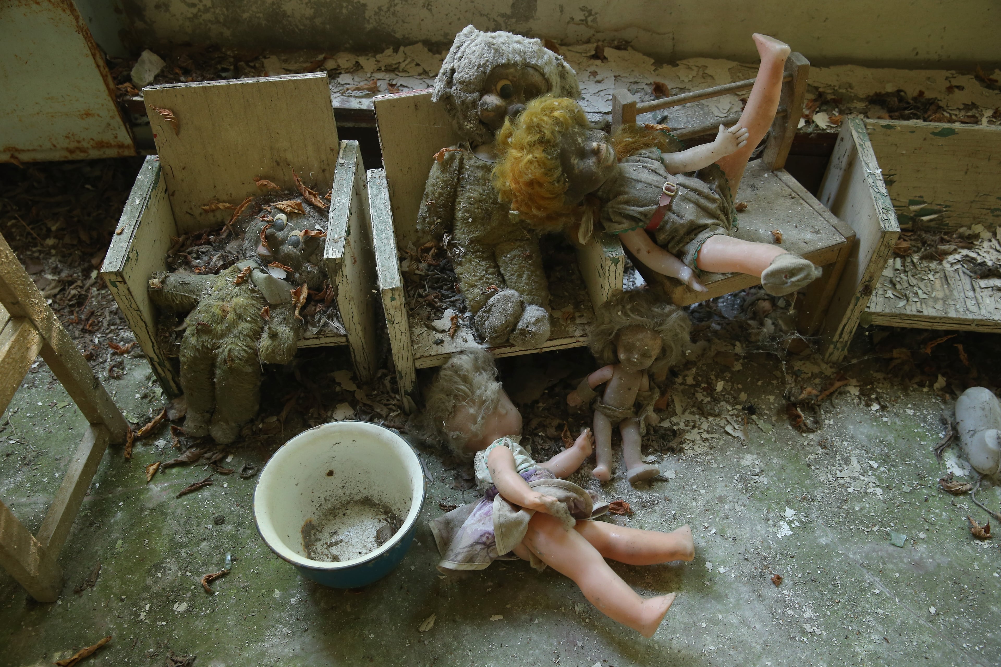 PRIPYAT, UKRAINE - SEPTEMBER 30: Dolls and stuffed animals lie in the "Zlataya ribka" ("Golden little fish") abandoned kindergarten on September 30, 2015 in Pripyat, Ukraine. Pripyat lies only a few kilometers from the former Chernobyl nuclear power plant and was built in the 1970s to house the plant's workers and their families. On April 26, 1986, technicians at Chernobyl conducting a test inadvertently caused reactor number four to explode, sending plumes of highly radioactive particles and debris into the atmosphere. Authorities evacuated 120,000 people from the area, including 43,000 from Pripyat. Today Pripyat is a ghost-town, its apartment buildings, shops, restaurants, hospital, schools, cultural center and sports facilities derelict and its streets overgrown with trees. The city lies in the inner exclusion zone around Chernobyl where hot spots of persistently high levels of radiation make the area uninhabitable for thousands of years to come. (Photo by Sean Gallup/Getty Images)