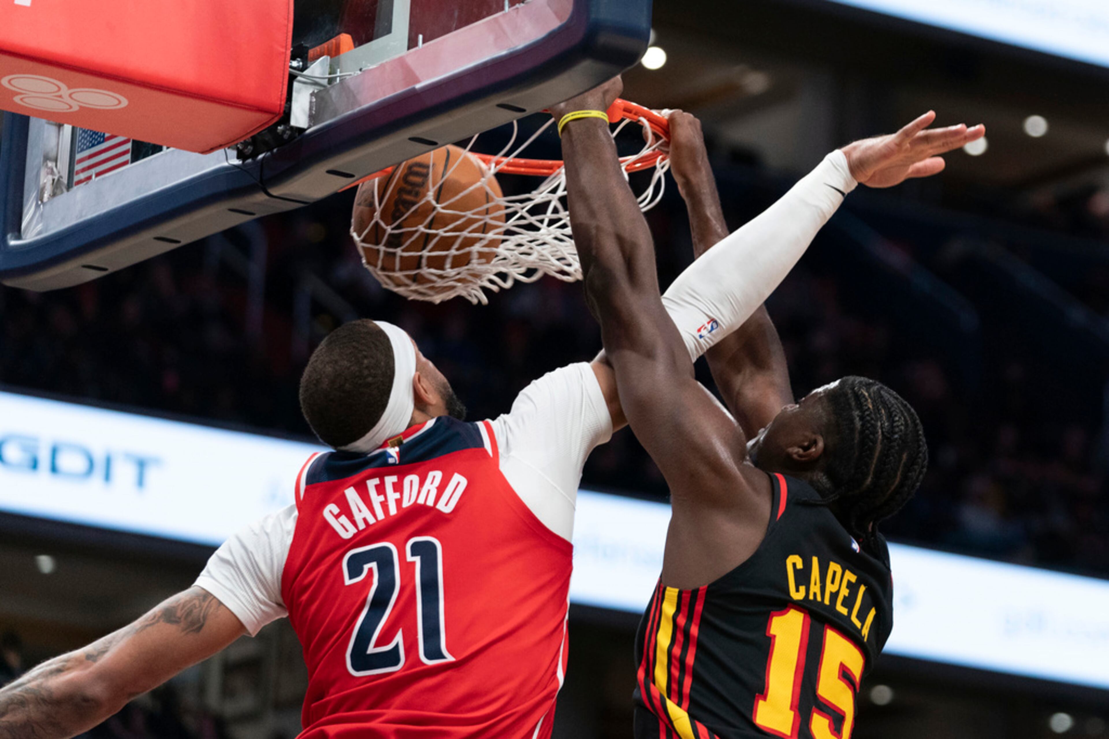 Atlanta Hawks' Clint Capela (15) dunks as Washington Wizards' Daniel Gafford (21) tries to block during the second half of an NBA basketball game Sunday, Dec. 31, 2023, in Washington. The Hawks defeated the Wizards 130-126. (AP Photo/Jose Luis Magana)