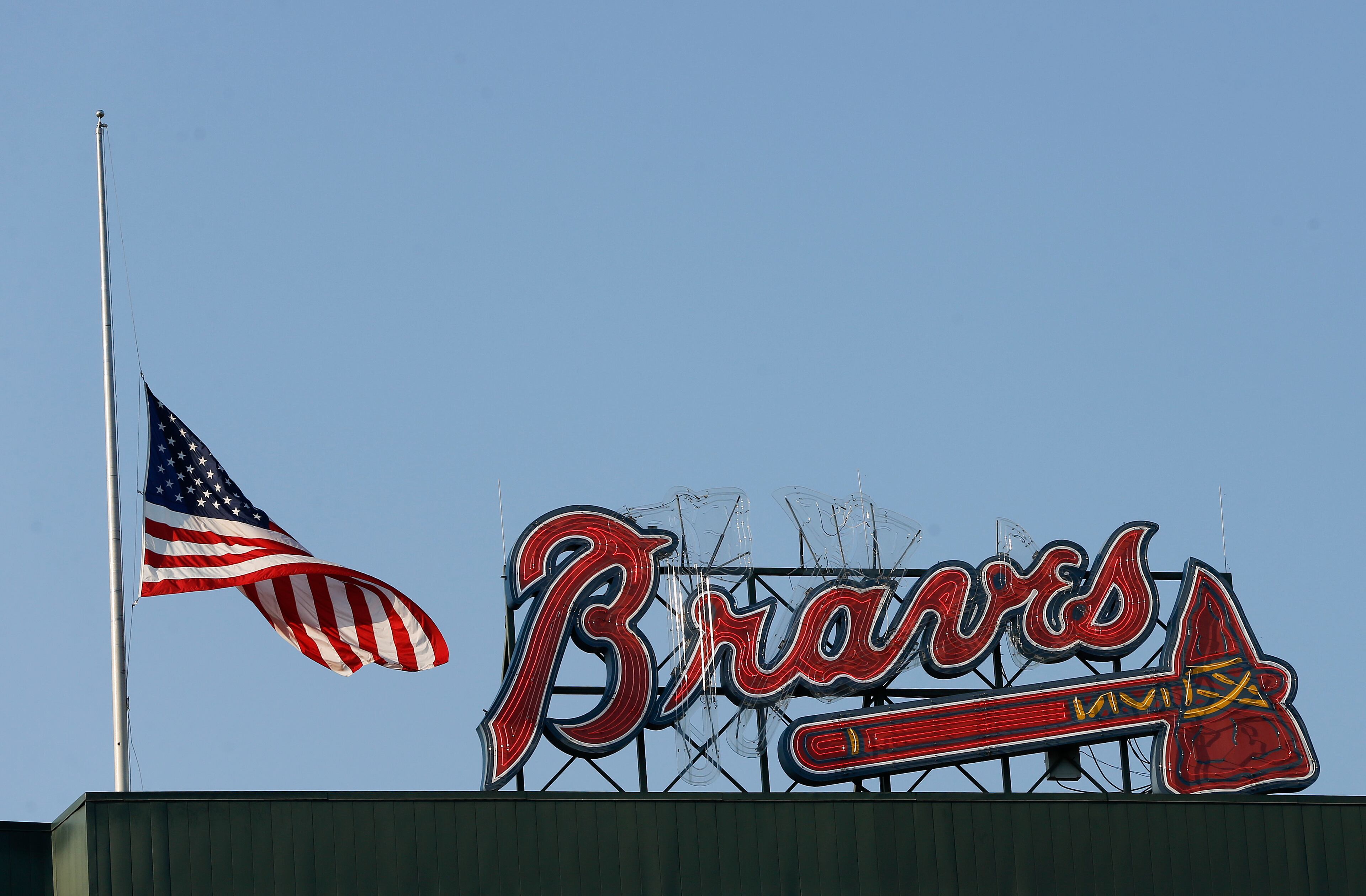 A U.S. flag flies at half-staff near the scoreboard at Turner Field during a game between the Braves and the Reds on Monday, June 13, 2016. (AP Photo/John Bazemore)