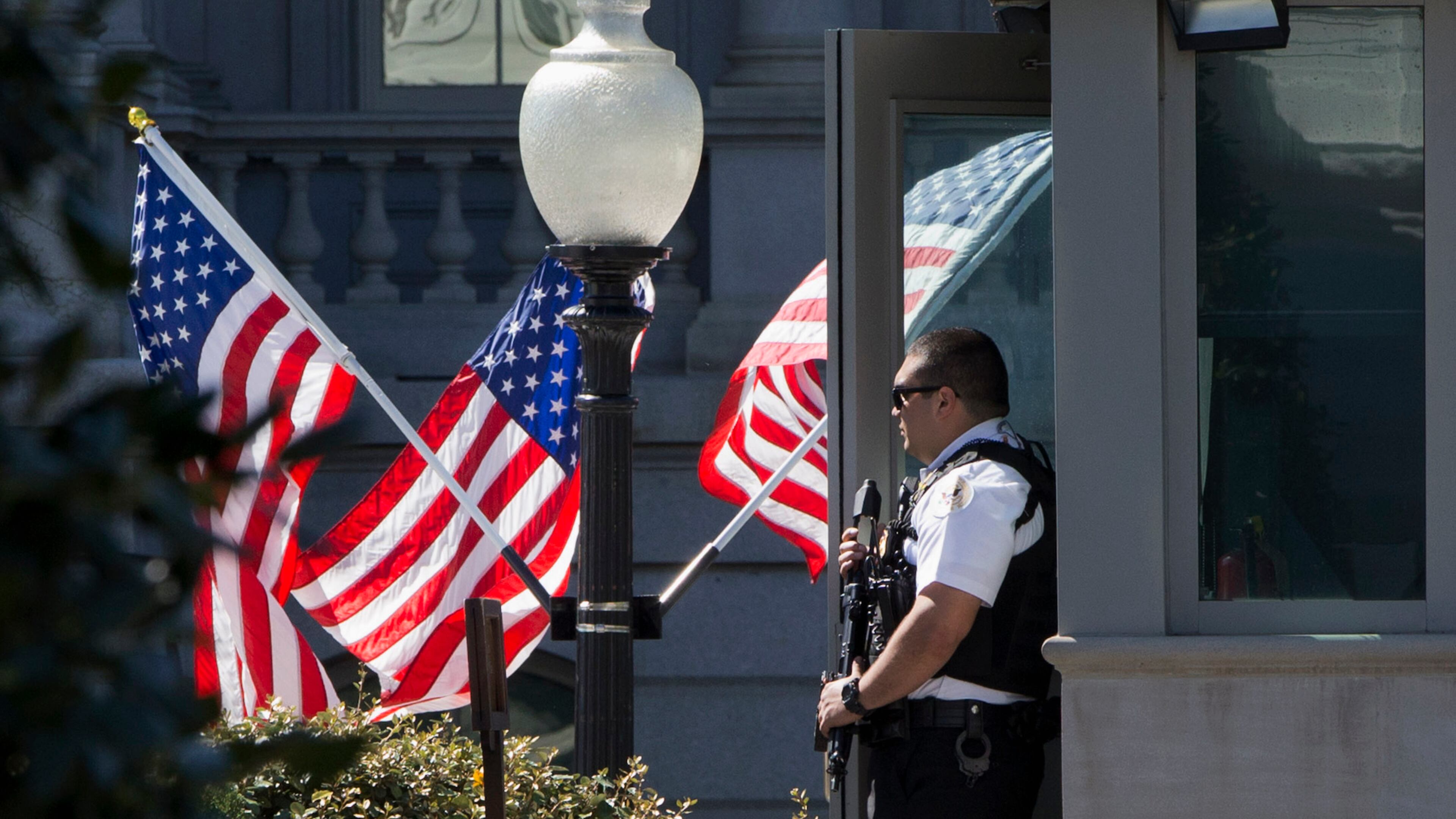 A Secret Service Uniformed Division Officer holds his weapon by a guard booth by the West Wing of the White House in Washington, Monday, March 28, 2016, after reports of an active shooter at the U.S. Capitol. (AP Photo/Jacquelyn Martin)