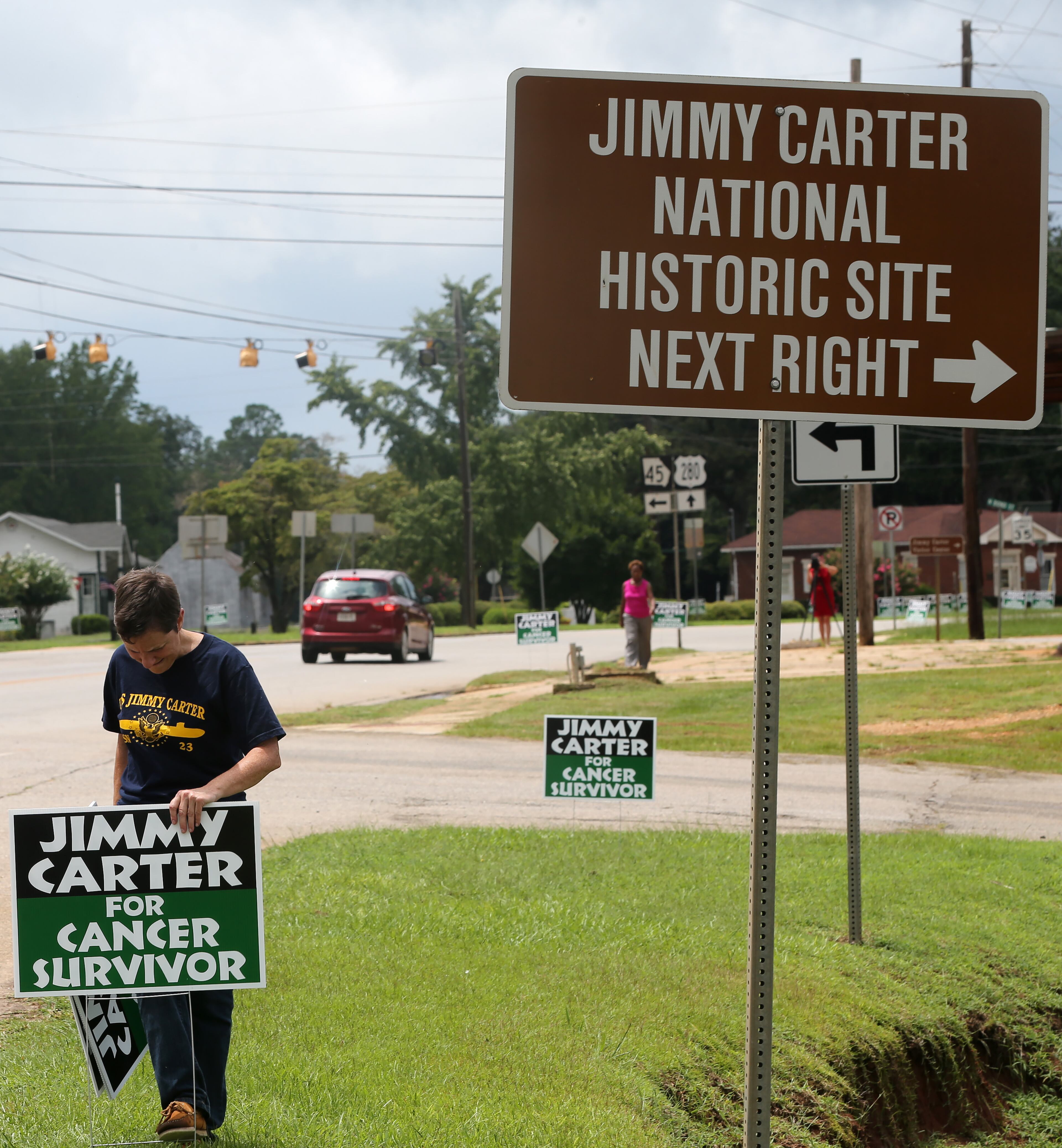 Jill Stuckey places "Jimmy Carter for Cancer Survivor" signs along the road leading into Plains on Thursday afternoon August 20, 2015 in advance of the President's return to his hometown. Ben Gray / bgray@ajc.com
