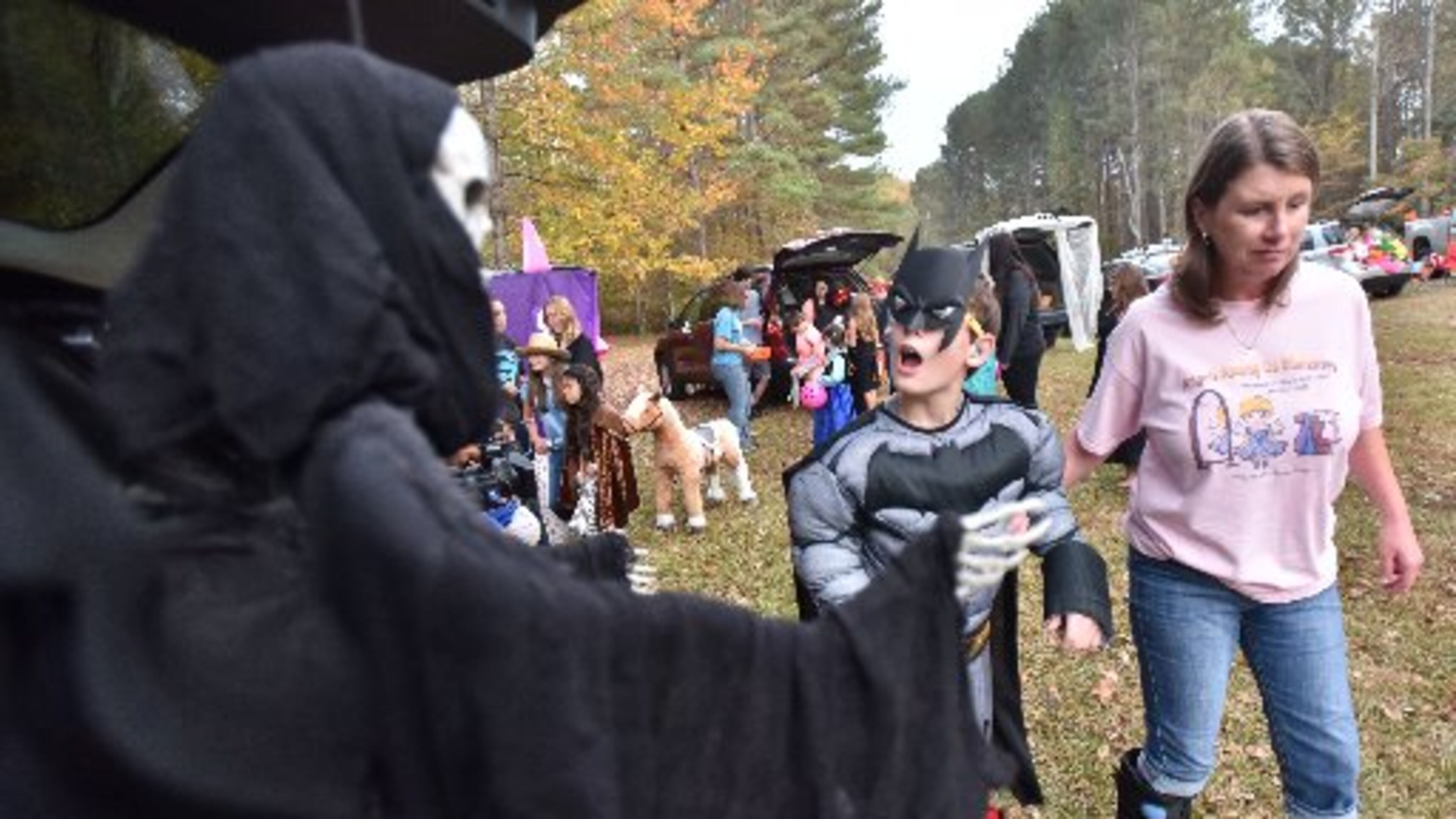 David Dakake, 12, reacts as Tina Watson (right) assists him during a special trunk-or-treat Wednesday night in Paulding County. (HYOSUB SHIN / HSHIN@AJC.COM)