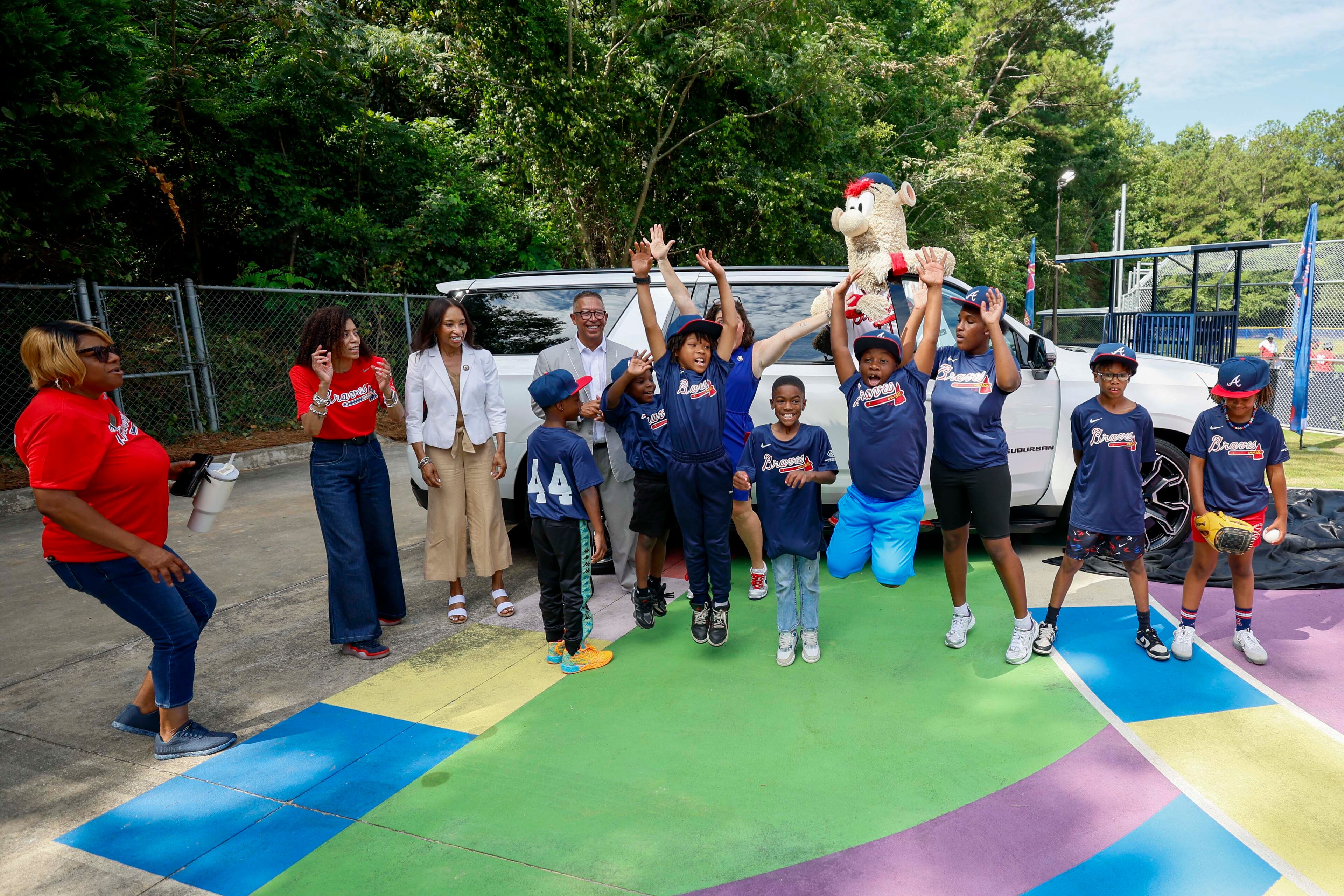 Kids and staff from the Barksdale Boys & Girls Club in Conyers celebrate on Thursday, July 10, 2025, after they unveil the vehicle donated to the club to take kids to and from practice. (Miguel Martinez/ AJC)