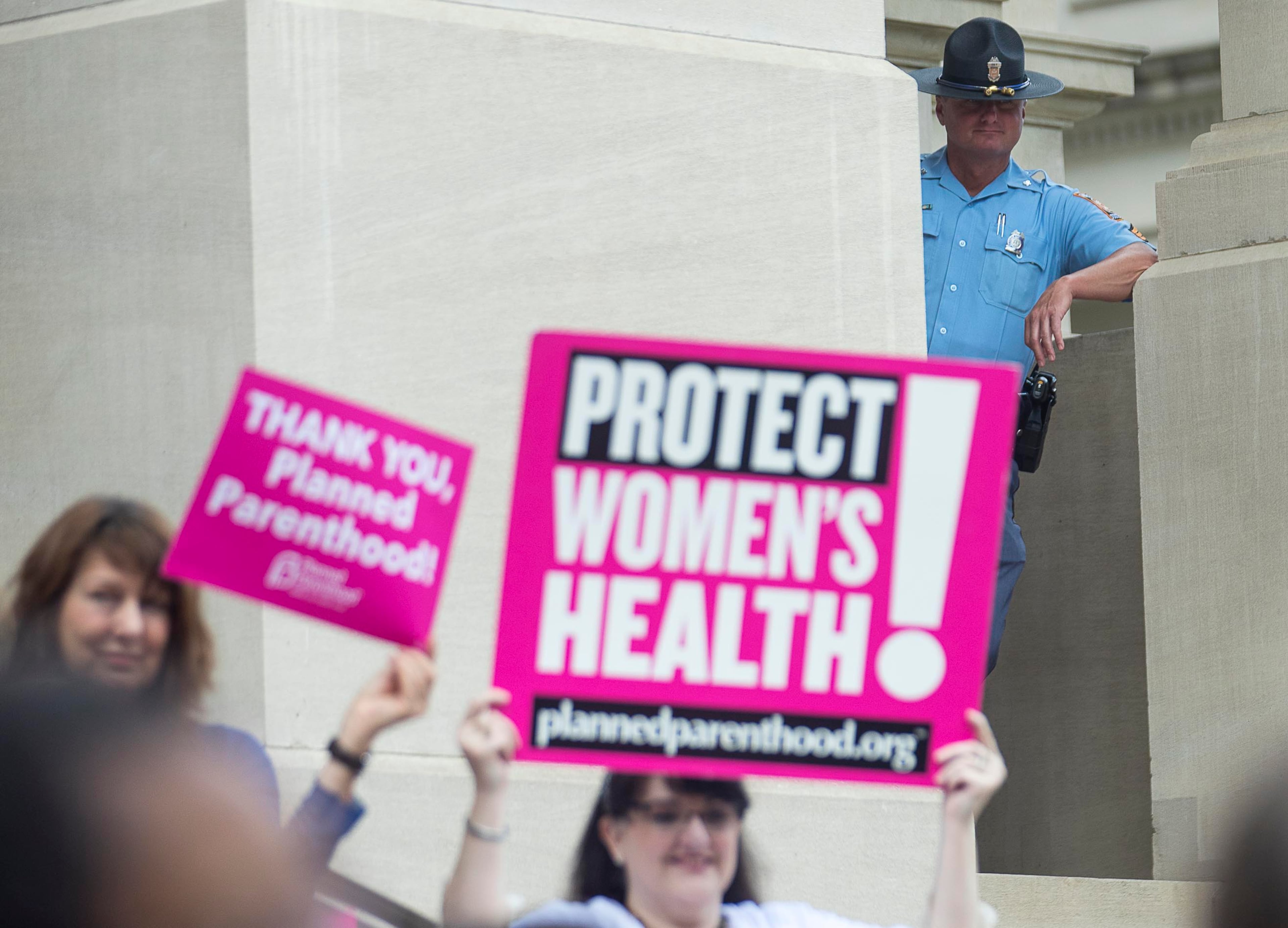 05/07/2019 -- Atlanta, Georgia -- A Georgia State Trooper watches over a crowd of anti-abortion protestors as they rally outside of the Georgia State Capitol building following the signing of HB 481 in Atlanta, Tuesday, May 7, 2019. Georgia Governor Brian Kemp signed the bill, surrounded by supporters and Georgia lawmakers, in his office Tuesday morning. (ALYSSA POINTER/ALYSSA.POINTER@AJC.COM)