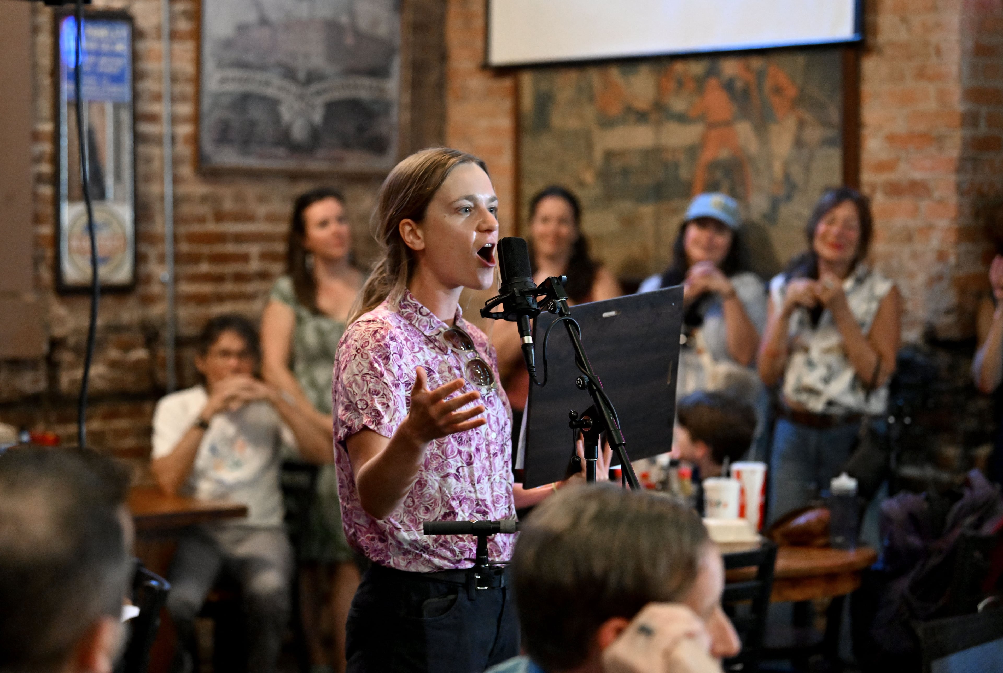 Atlanta City Council member Kelsea Bond reads a proclamation honoring Manuel’s Tavern during its 70th anniversary celebration on Thursday, Aug. 6, 2026. This caption has been updated to correct the spelling of Kelsea Bond. (Hyosub Shin/AJC)