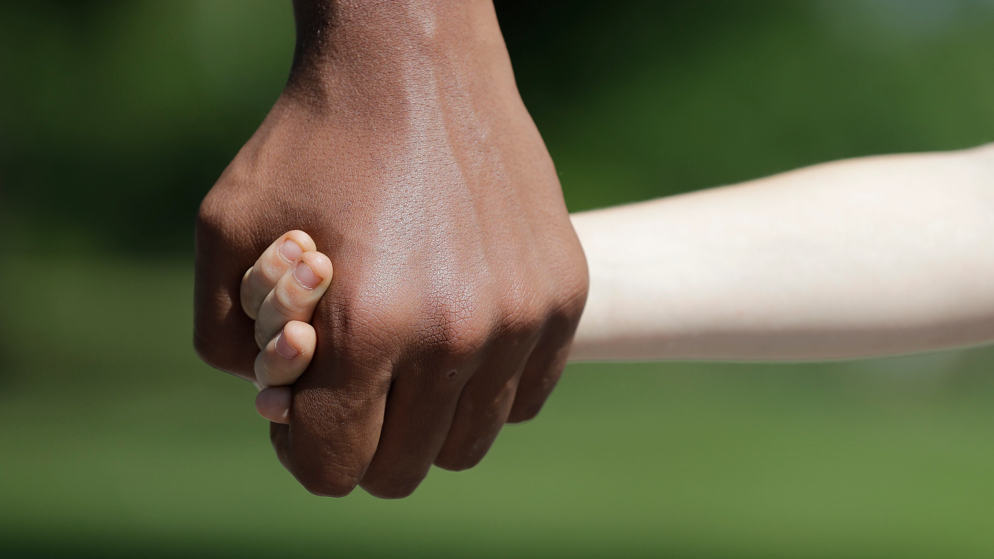 Belachew Neal holds hands with his younger brother, Elisha, in Indianapolis. The Associated Press discussed race with six white couples who have adopted or have custody of Black children.