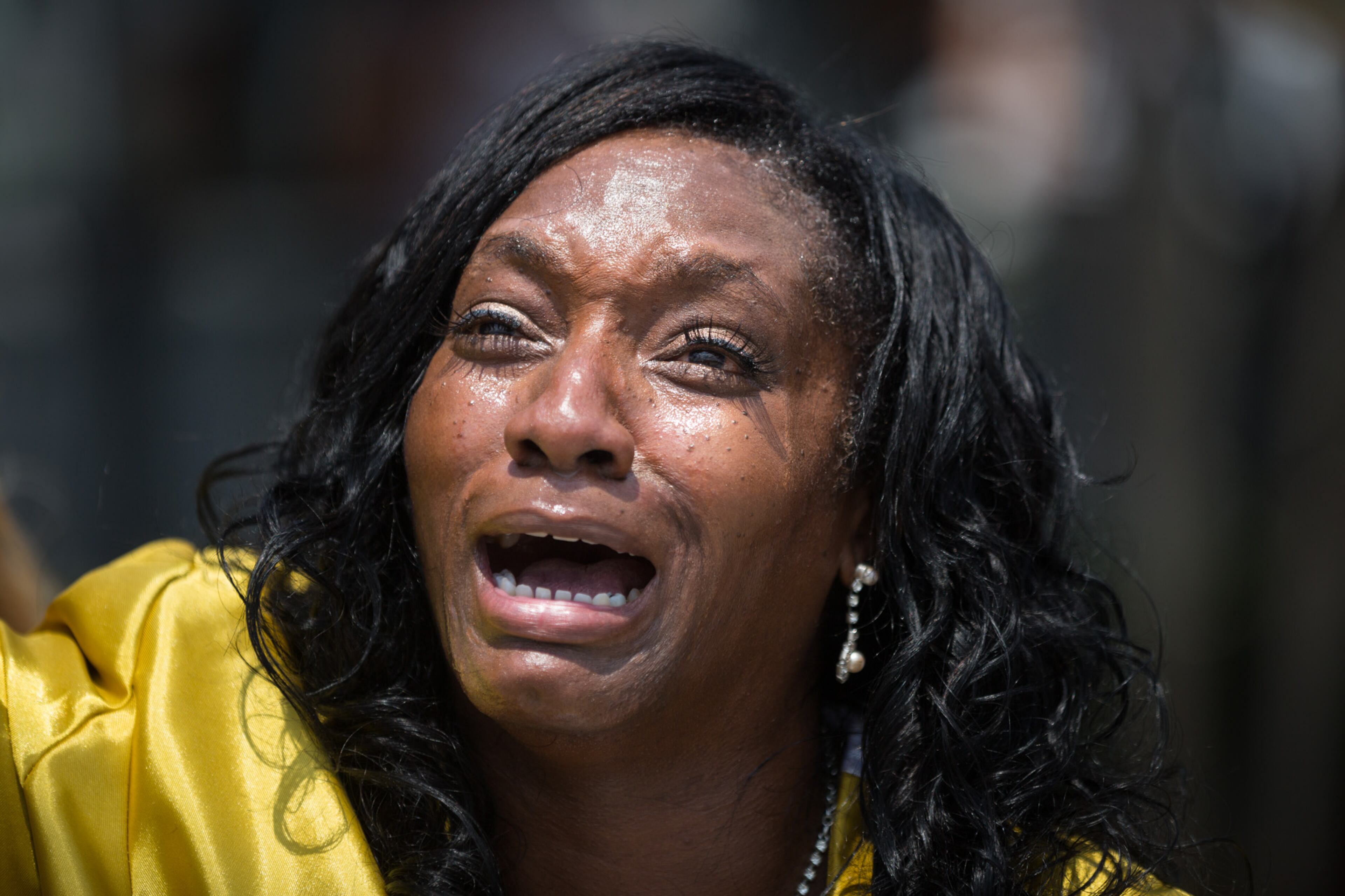 Annette Stubbs, a pastor at a local church, prays for victims a few blocks from a crime scene at the nightclub where a mass shooting took place the night before in Orlando, Fla., Sunday, June 12, 2016. A gunman opened fire inside the gay nightclub early Sunday, killing at least 50 people before dying in a gunfight with SWAT officers, police said. (Loren Elliott/Tampa Bay Times via AP)