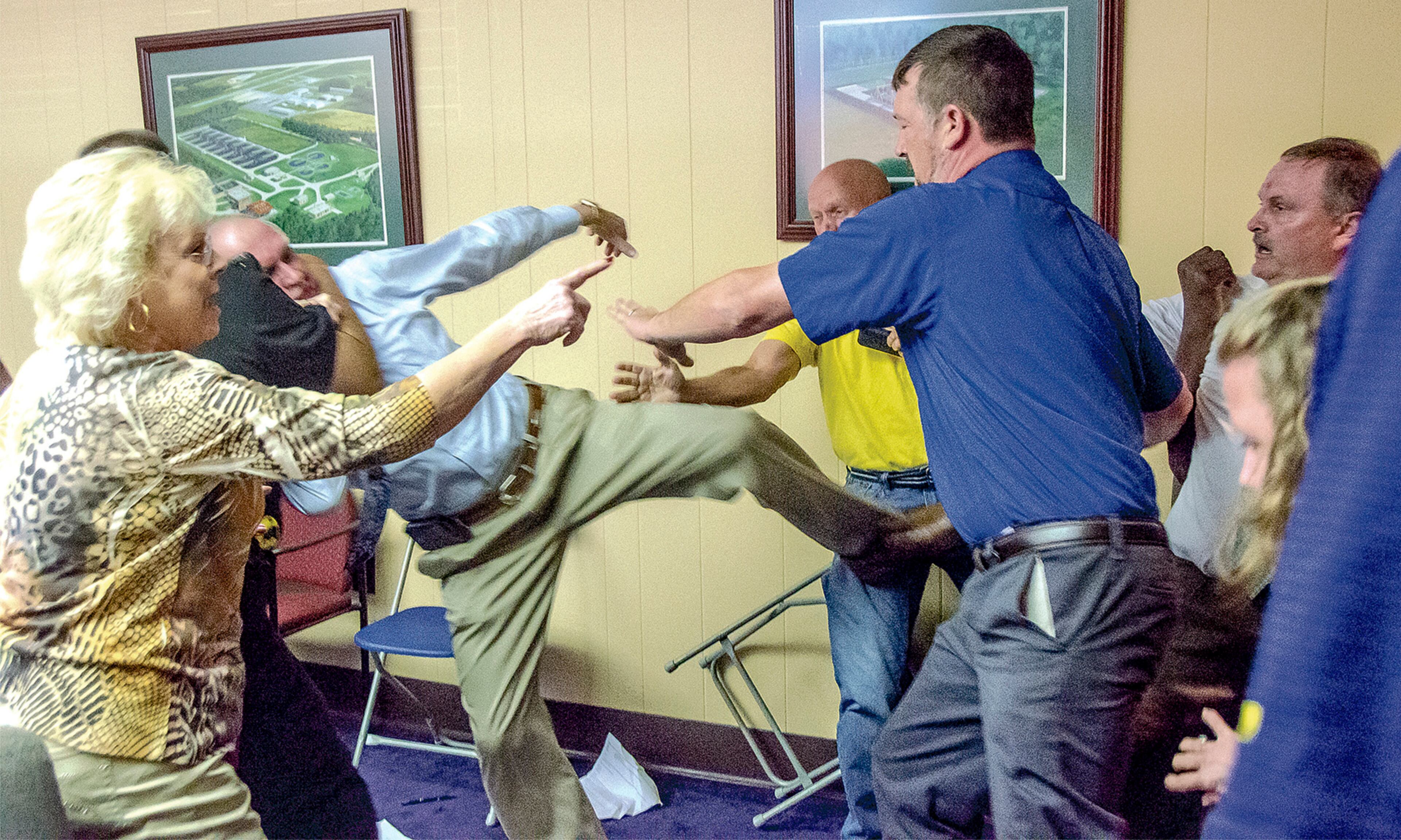 COUNCIL SCUFFLE--Alexander City, Ala Mayor Charles Shaw, left, is restrained by an officer after a fight broke out between him and councilman Tony Goss, far right, during a meeting of the Alexander City City Council in Alexander City, Ala. on Monday, April 25, 2016. Those attending the meeting along with officers had to intervene after the meeting adjourned. The incident took place at Alexander City City Hall and was intended to discuss city audits and other municipal financial issues but the meeting broke down to a shouting match before it ended and the brawl ensued. (Mitch Sneed/Alexander City Outlook via AP)