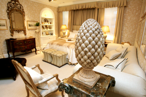 In the master bedroom, renowned designer Dan Carithers used creams and beige fabrics to give the room a peaceful feel. The walls are covered in fabric a technique Carithers employed throughout the home.