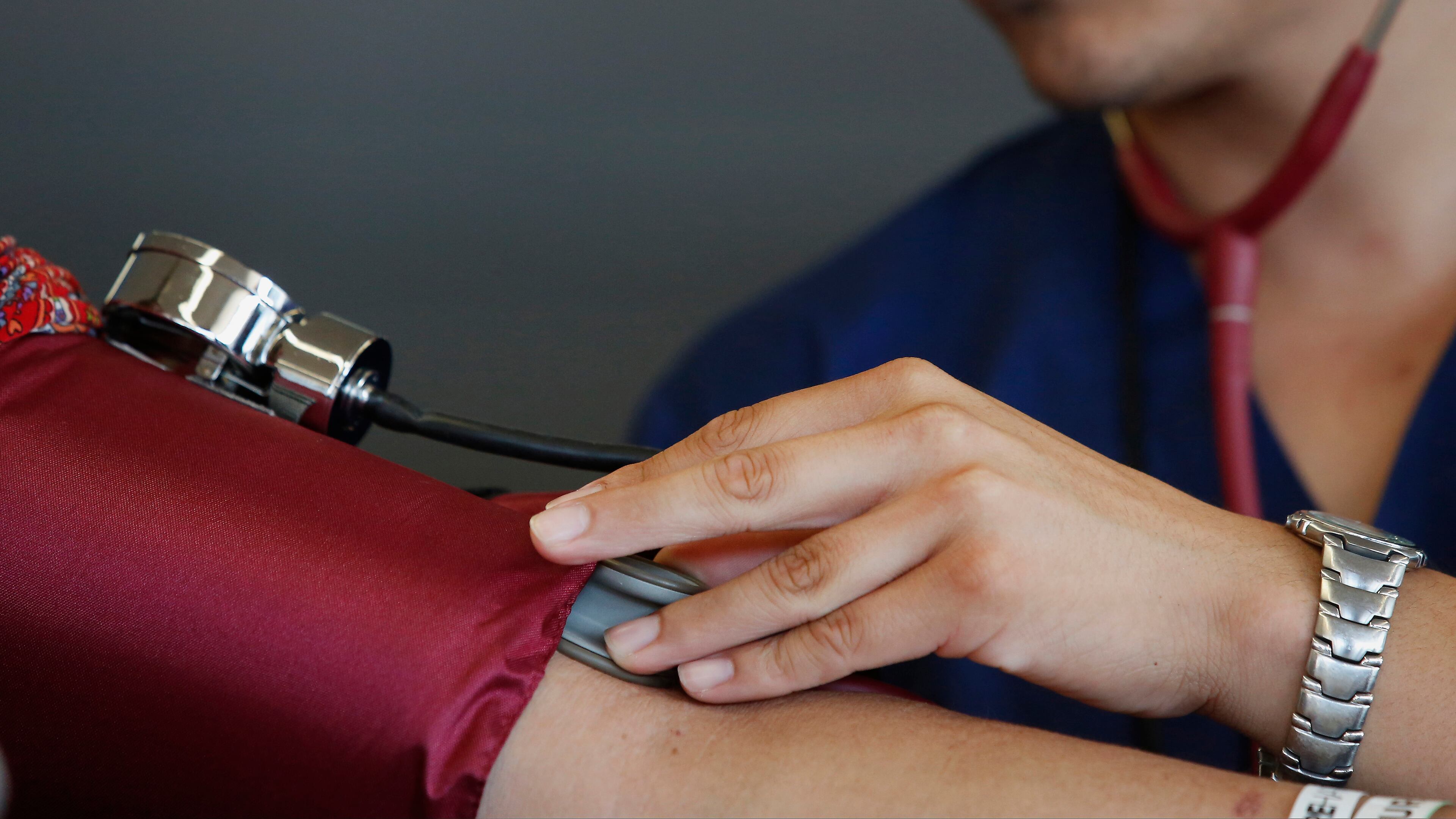A health-care aide checks the blood pressure of a patient during the Care Harbor Public Health Clinic event at the Los Angeles Sports Arena on Sept. 11, 2014. Photo: Patrick T. Fallon/Bloomberg