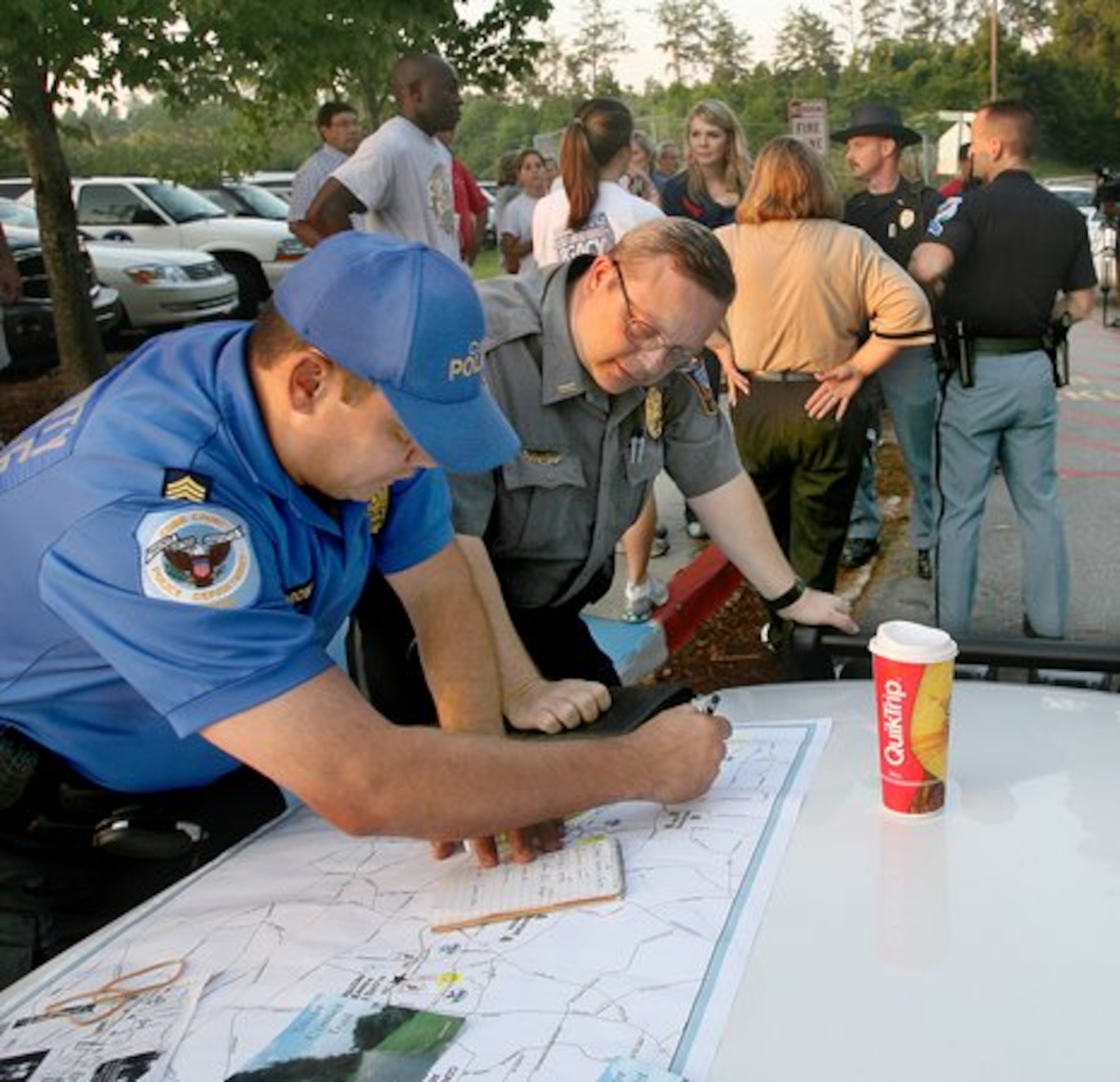 After Jennifer Ewing was reported missing in July 2006, police, friends, relatives and other volunteers searched along the Silver Comet Trail. Cobb County police Sgt. R. Sorrow (left) discusses search strategies with Smyrna police officer, N.R. Johnson.