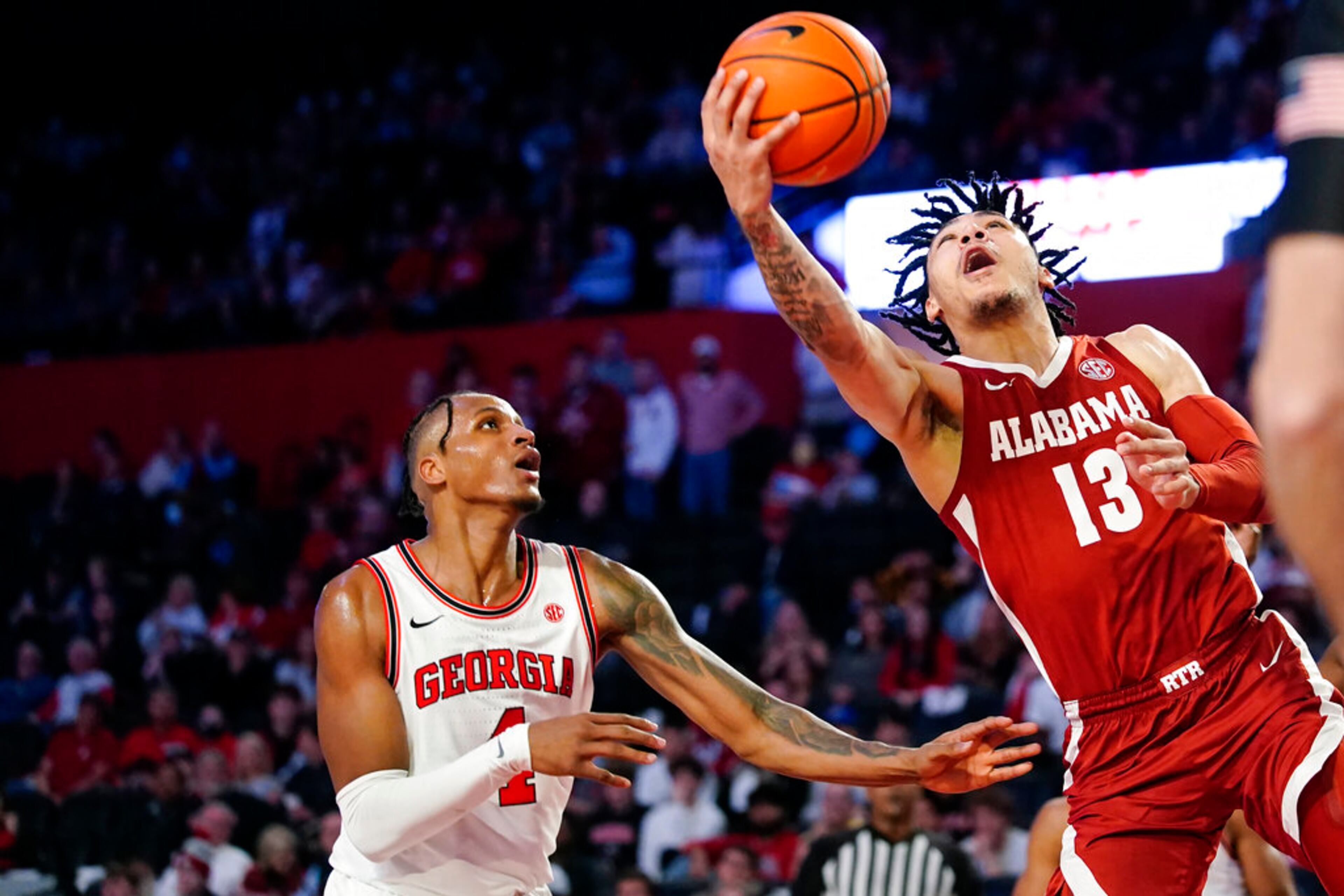 Alabama guard Jahvon Quinerly (13) goes up for a shot as Georgia forward Tyron McMillan (4) defends in the first half of an NCAA college basketball game Tuesday, Jan. 25, 2022, in Athens, Ga. (AP Photo/John Bazemore)