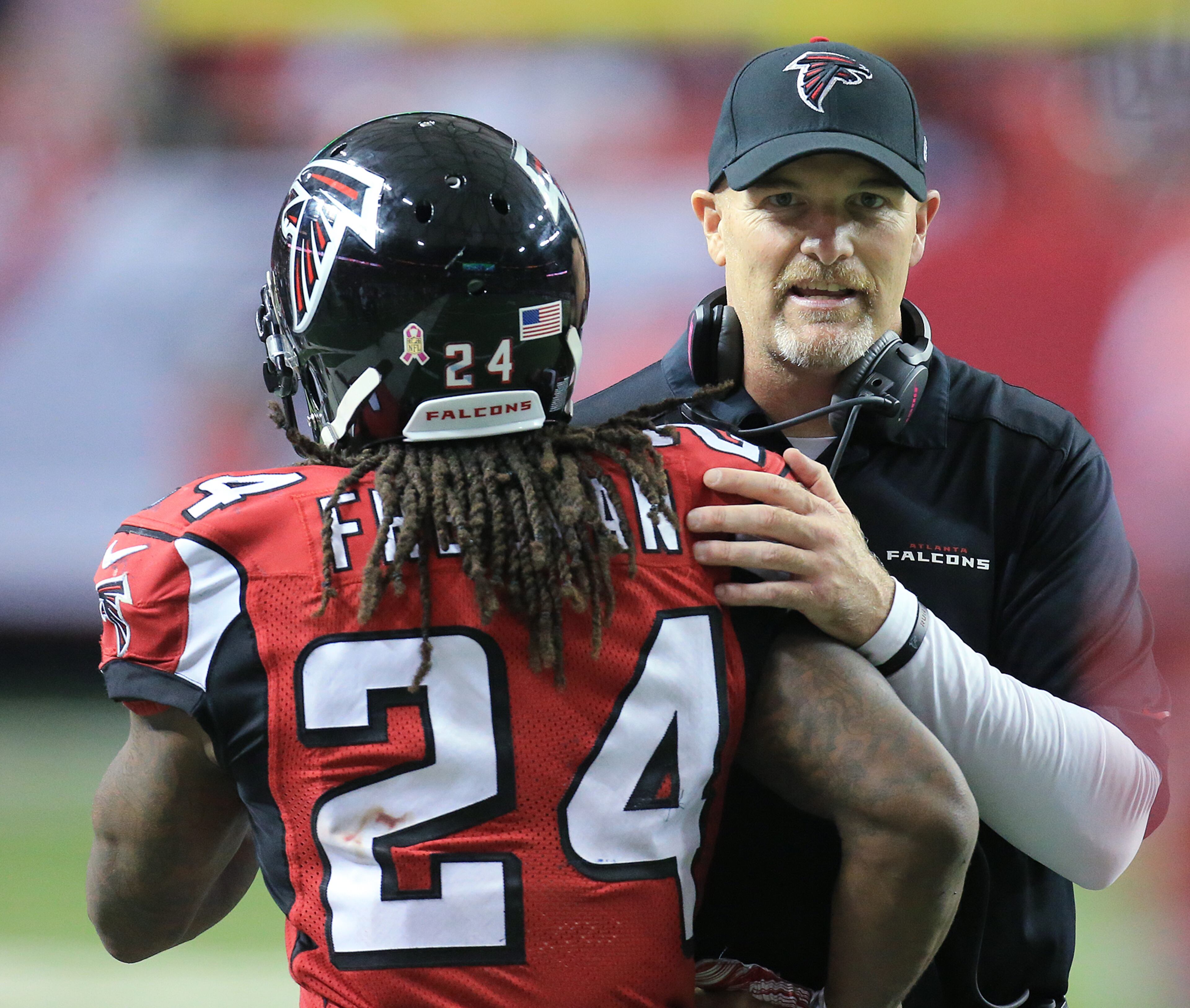 Falcons running back Devonta Freeman gets a pat on the back from head coach Dan Quinn after his third touchdown of the day against the Texans for a 35-0 lead during the third quarter in a football game on Sunday, Oct. 4, 2015, in Atlanta. The Falcons beat the Texans 48-21.