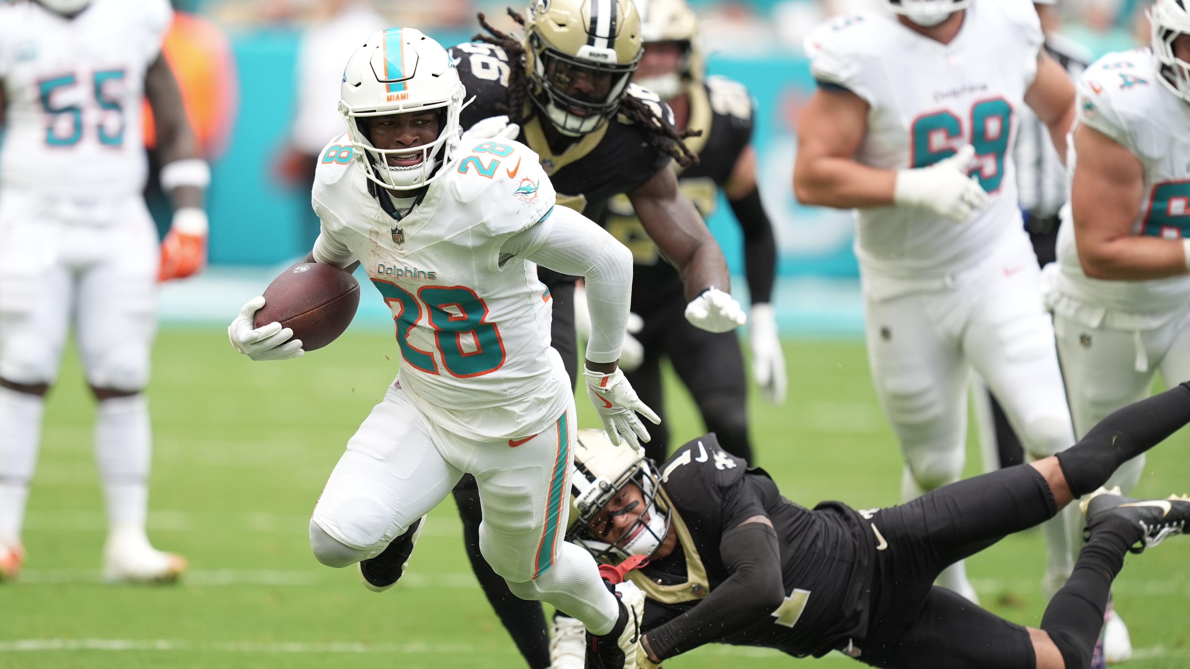 FILE - Miami Dolphins running back De'Von Achane (28) escapes a tackle by New Orleans Saints cornerback Alontae Taylor (1) during the first half of an NFL football game, Nov. 30, 2025, in Miami Gardens, Fla. (AP Photo/Rebecca Blackwell, File)