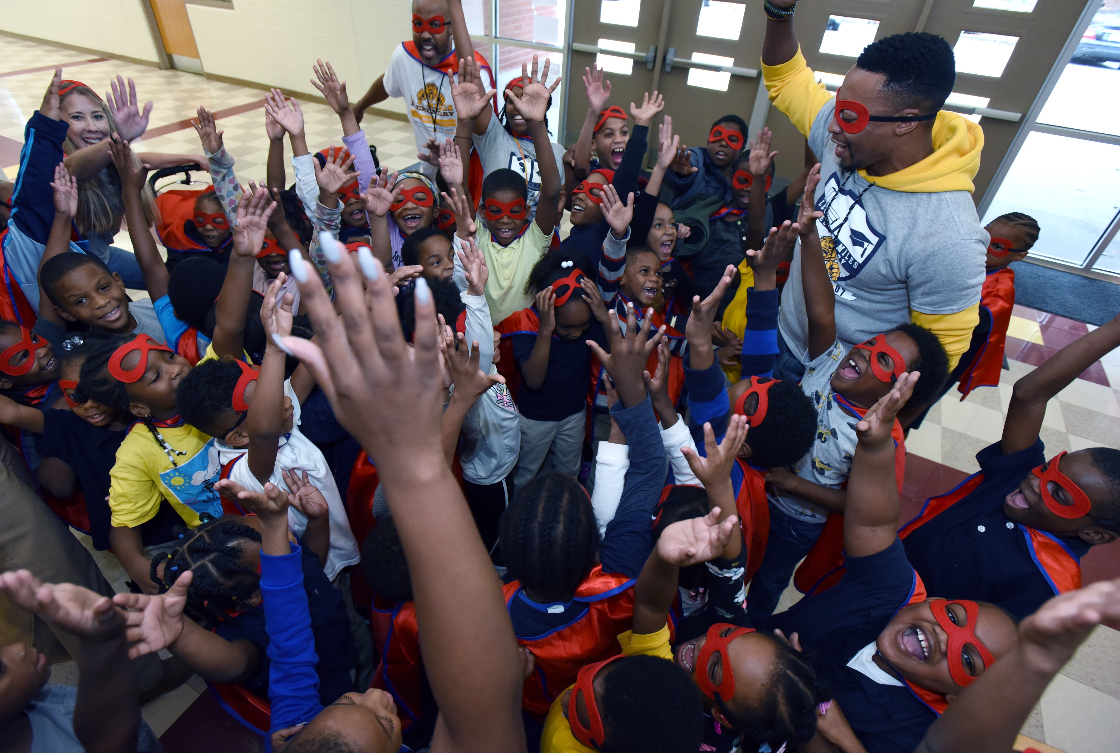 Assistant principal Robert Stewart (right) cheers students after they participated in the attendance run at Miles Elementary School on Friday, November 22, 2019. (Hyosub Shin / Hyosub.Shin@ajc.com)