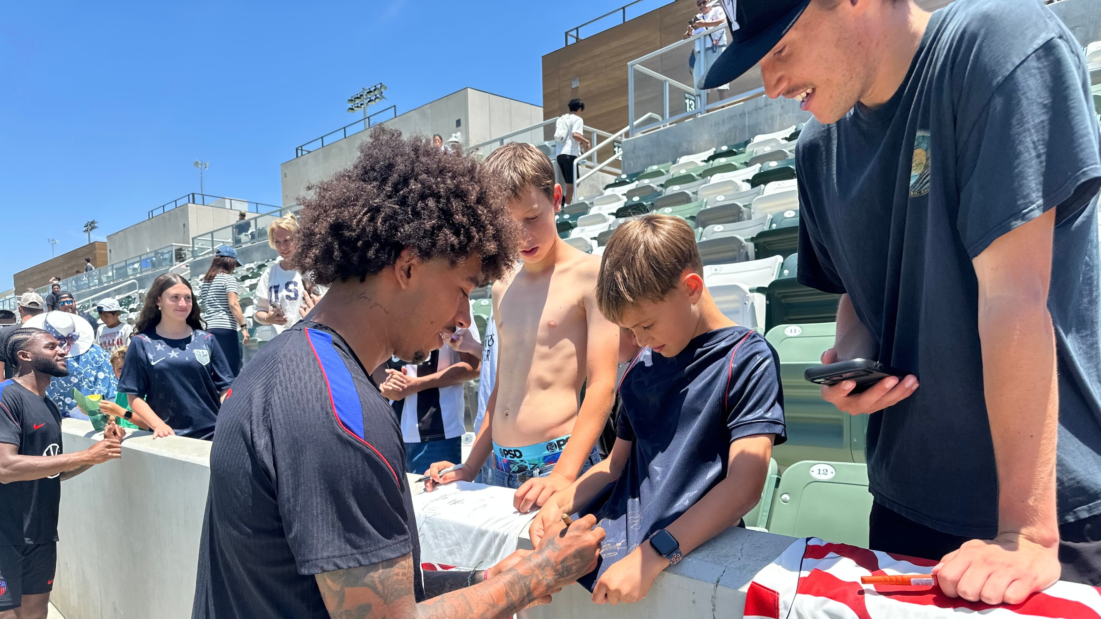 United States defender Chris Richards, front left, gives autographs to fans after the nationall team's first practice at its World Cup soccer tournament training base in Irvine, Calif., Monday, June 8, 2026. (AP Photo/Greg Beacham)