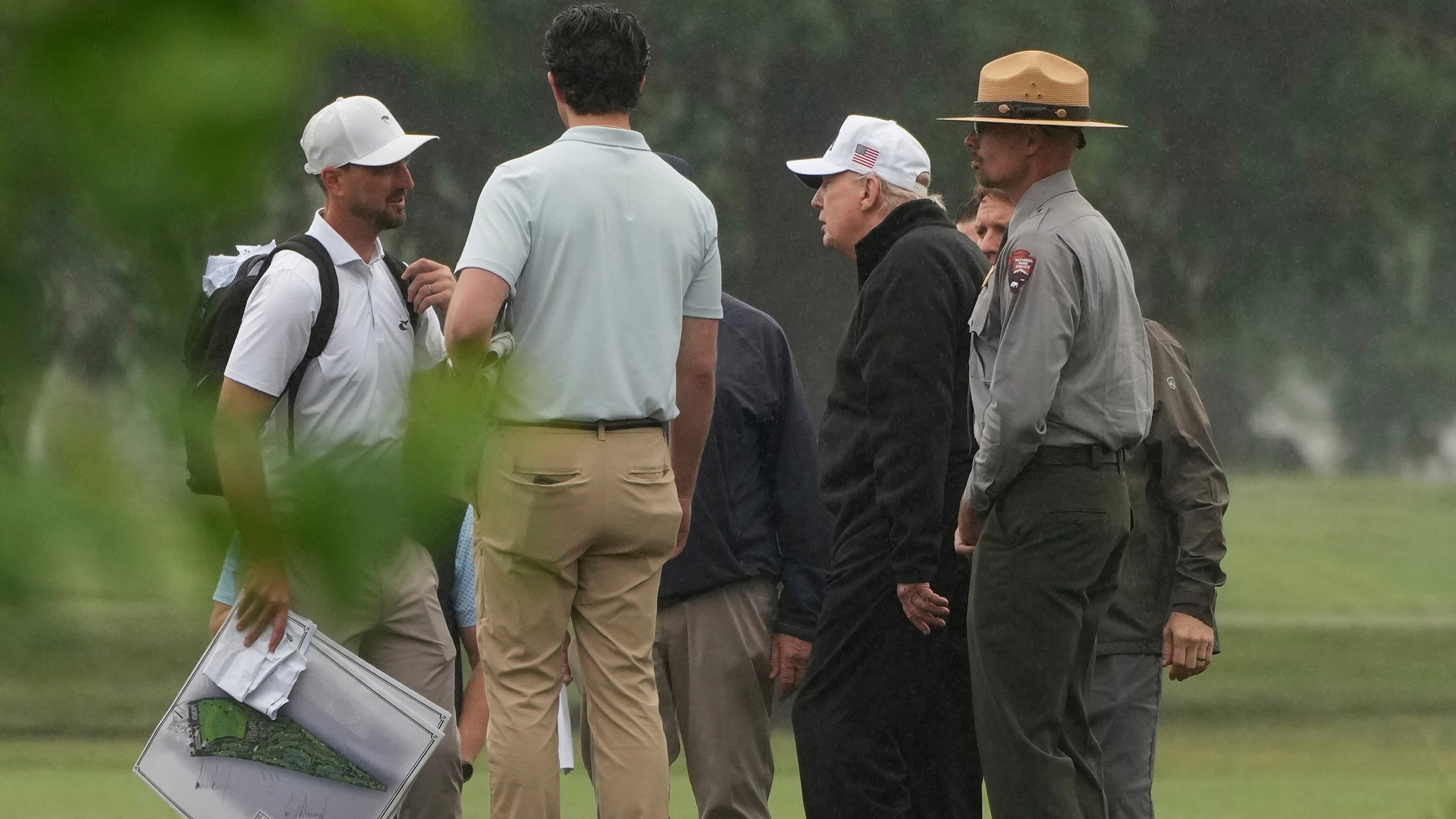 President Donald Trump, second right, tours the East Potomac Park golf course alongside a person carrying blueprints, Sunday, June 28, 2026, in Washington. (AP Photo/Mark Schiefelbein)