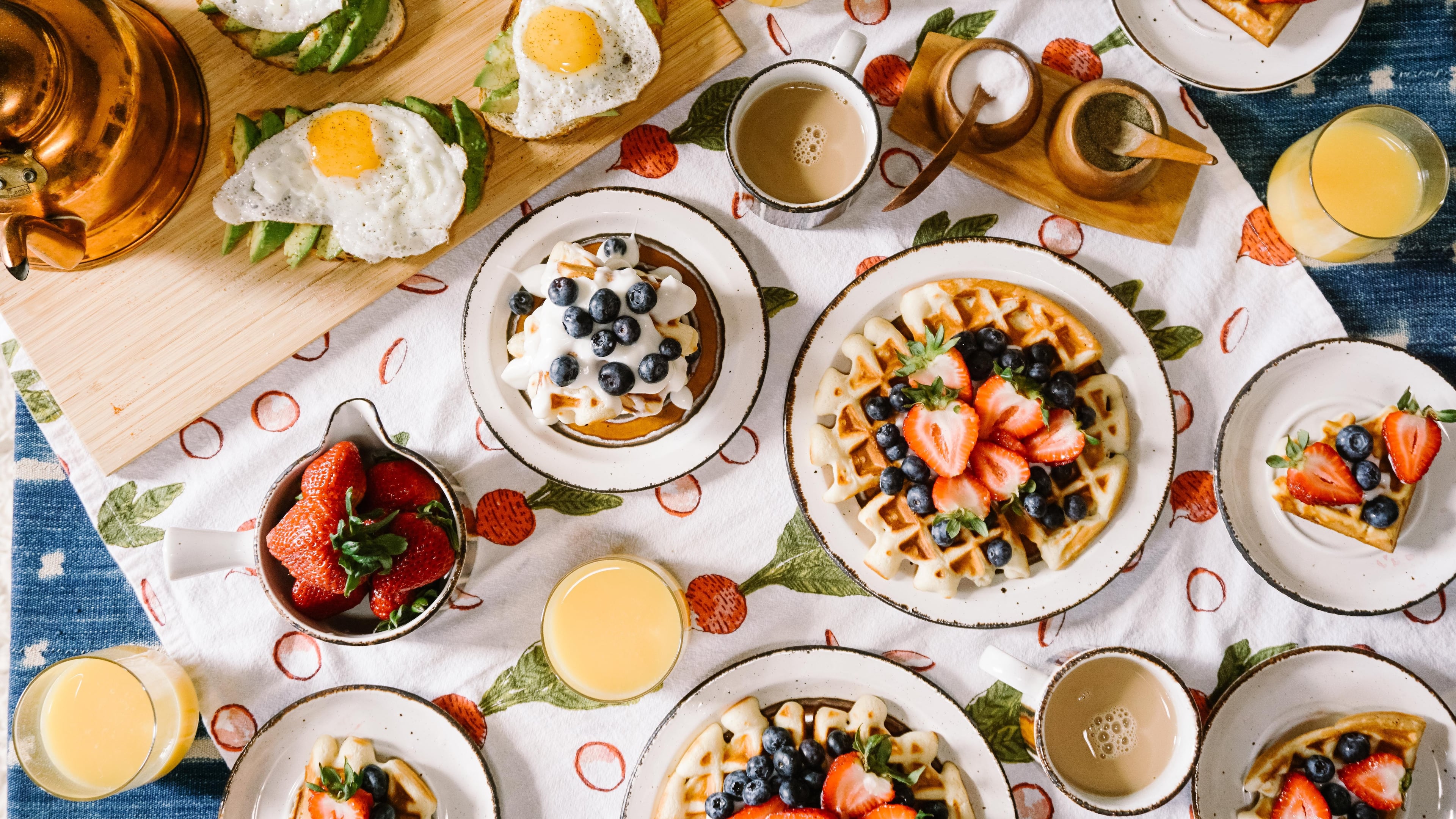 Round white ceramic plates filled with popular brunch foods.