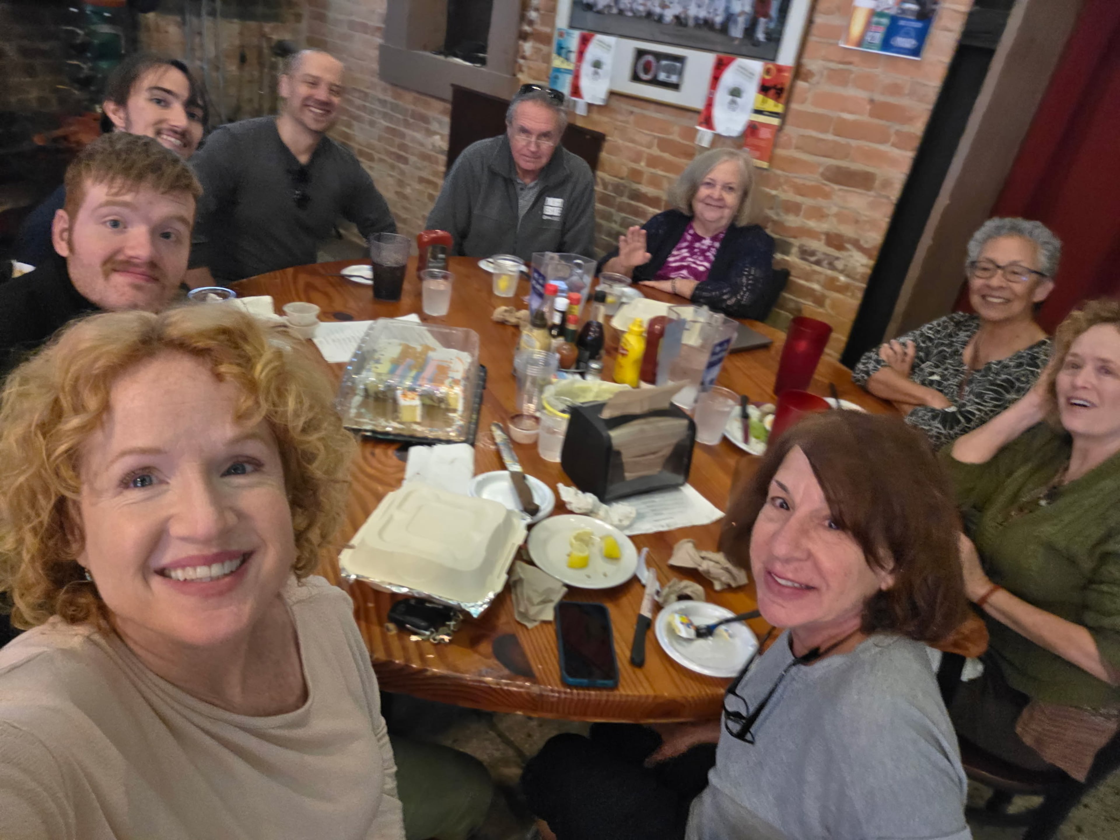 A group of Atlantans befriended a young gay Jamaican immigrant named Jerome Lawrence, who was deported. They gathered at Manuel's Tavern for his birthday, talking with him on Zoom. Lori Craven is left front, Jane Diamond is right front. LeAnne Lemmond has her back to the bricks in center. And Rev. Colin Holtz, is third man from left. (Courtesy Lori Craven)