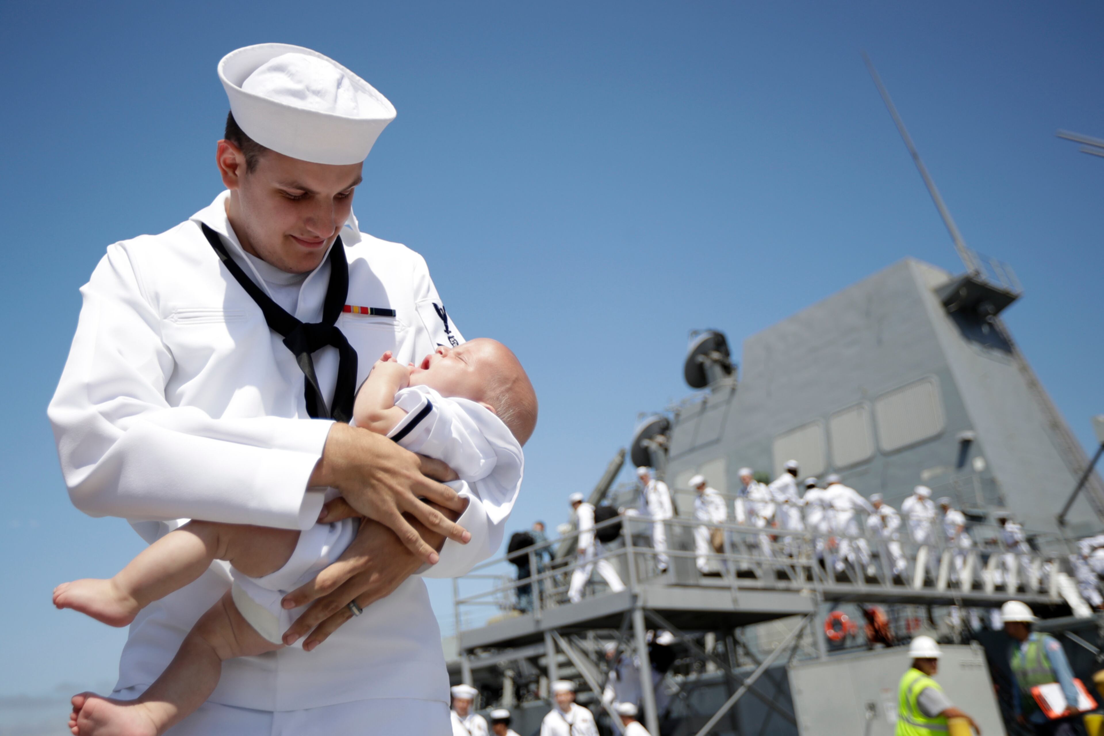 Navy Petty Officer Kyle Parrish holds his four-month-old son Benjamin, after arriving aboard the USS Dewey to Naval Base San Diego Monday, July 31, 2017, in San Diego. Dewey, an Arleigh Burke-class guided-missile destroyer, returned Monday after a four-month deployment to the Western Pacific. (AP Photo/Gregory Bull)