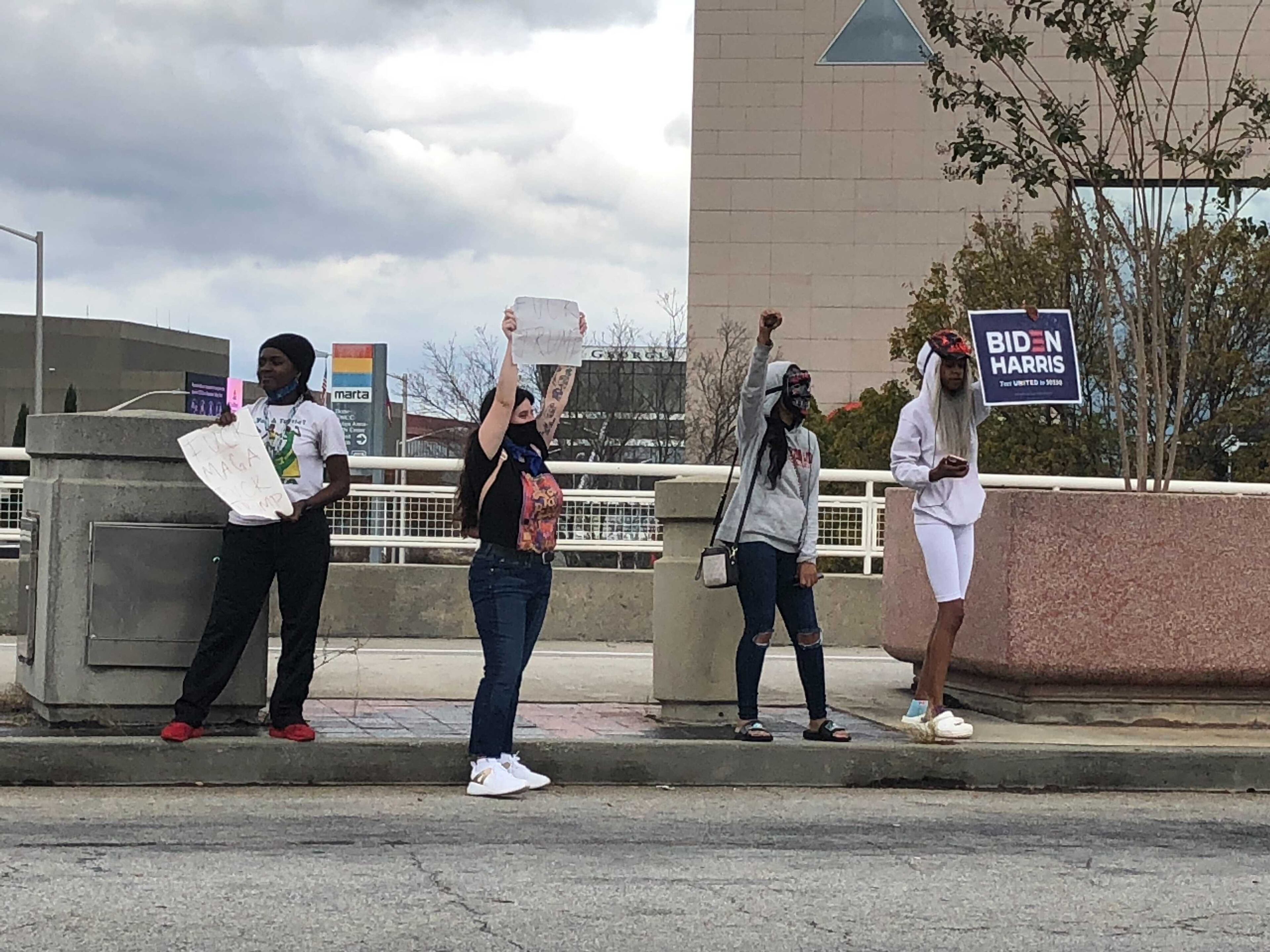 Supporters of Joe Biden hold signs near State Farm Arena in downtown Atlanta Saturday. (Janel Davis / AJC)