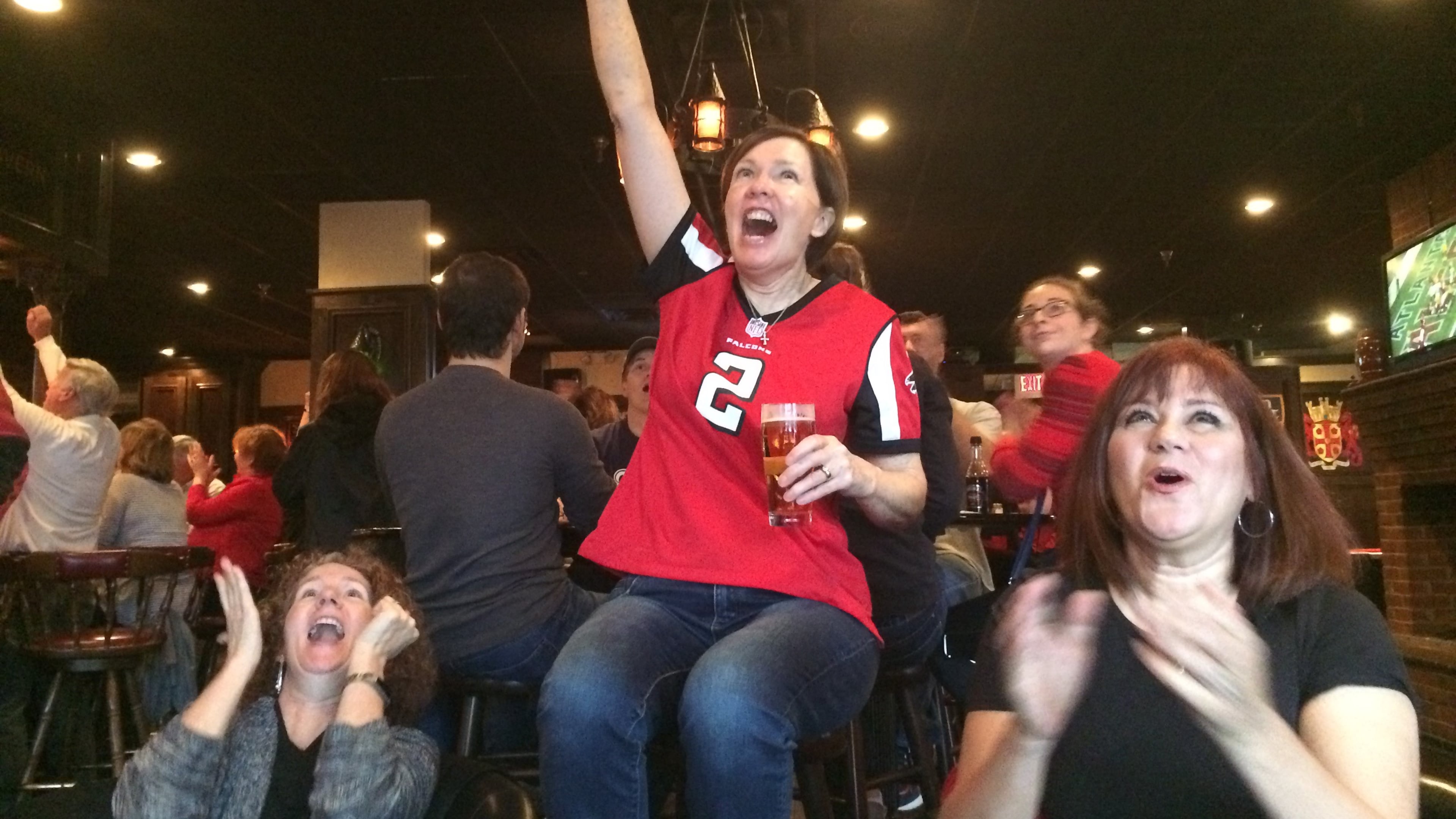 Dunwoody residents Cissy Holland, left, Patti Kish and Tina Tiede cheer a Falcons touchdown at Dunwoody Tavern during the NFC Championship Game. J. SCOTT TRUBEY/strubey@ajc.com