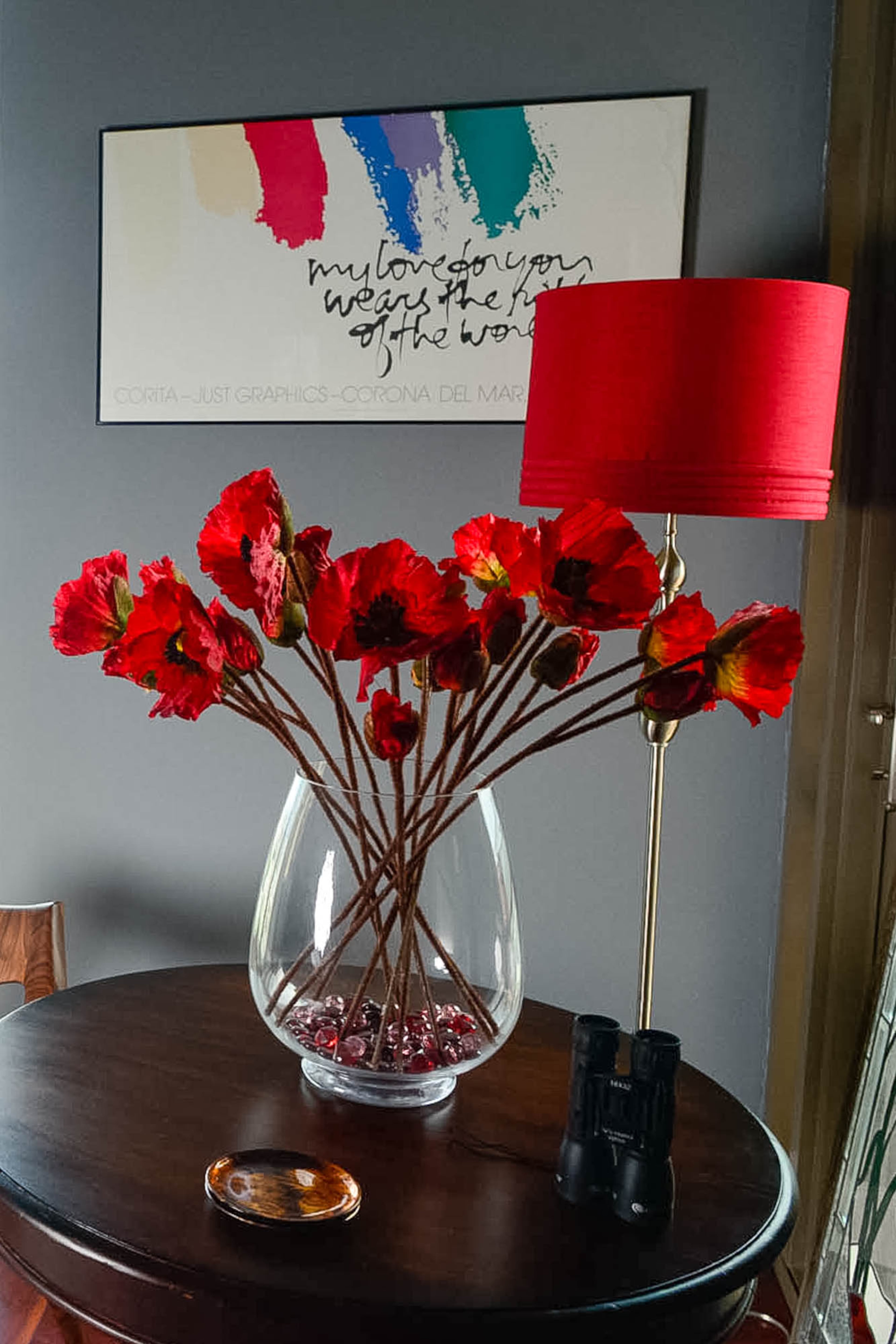 A baby grand piano, chandelier from Lighting Loft and bursts of red against gray walls add drama to the music nook overlooking the city.
