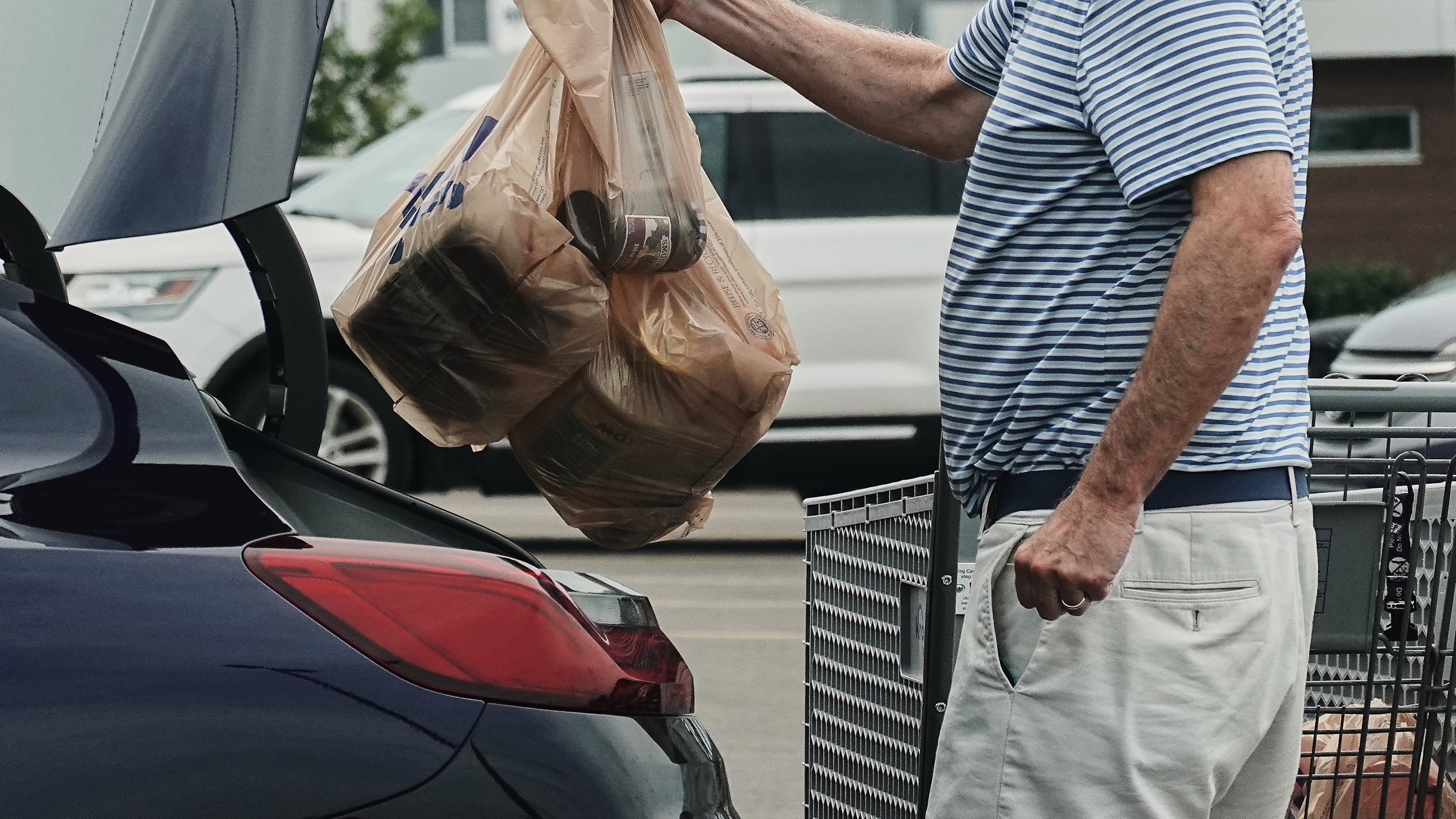 FILE - A person loads groceries in plastic bags into their vehicle, May 18, 2026, at a grocery store in Cincinnati. (AP Photo/Joshua A. Bickel, File)