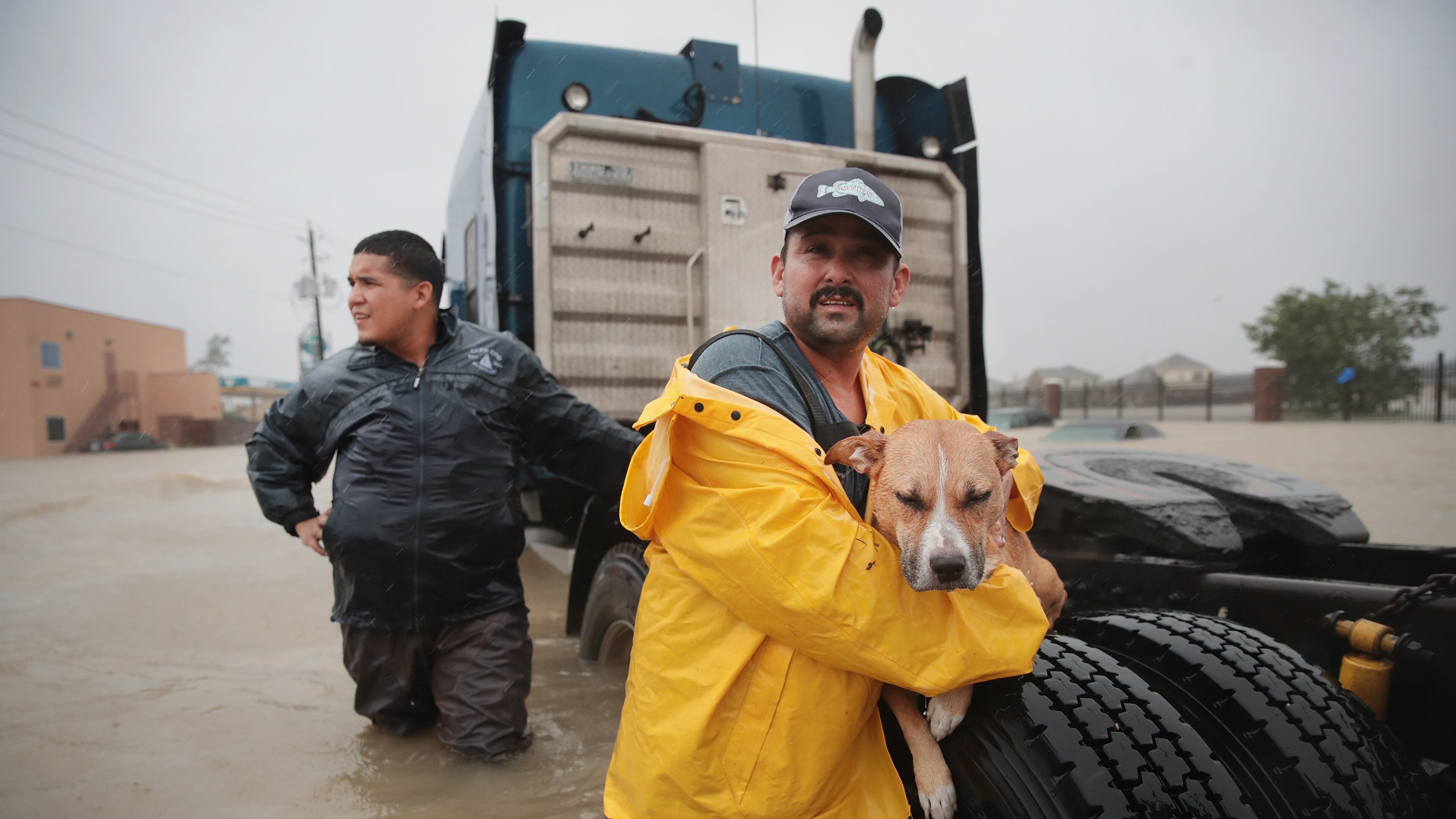 People make their way out of a flooded neighborhood after it was inundated with rain water, remnants of Hurricane Harvey, on August 28, 2017 in Houston, Texas.