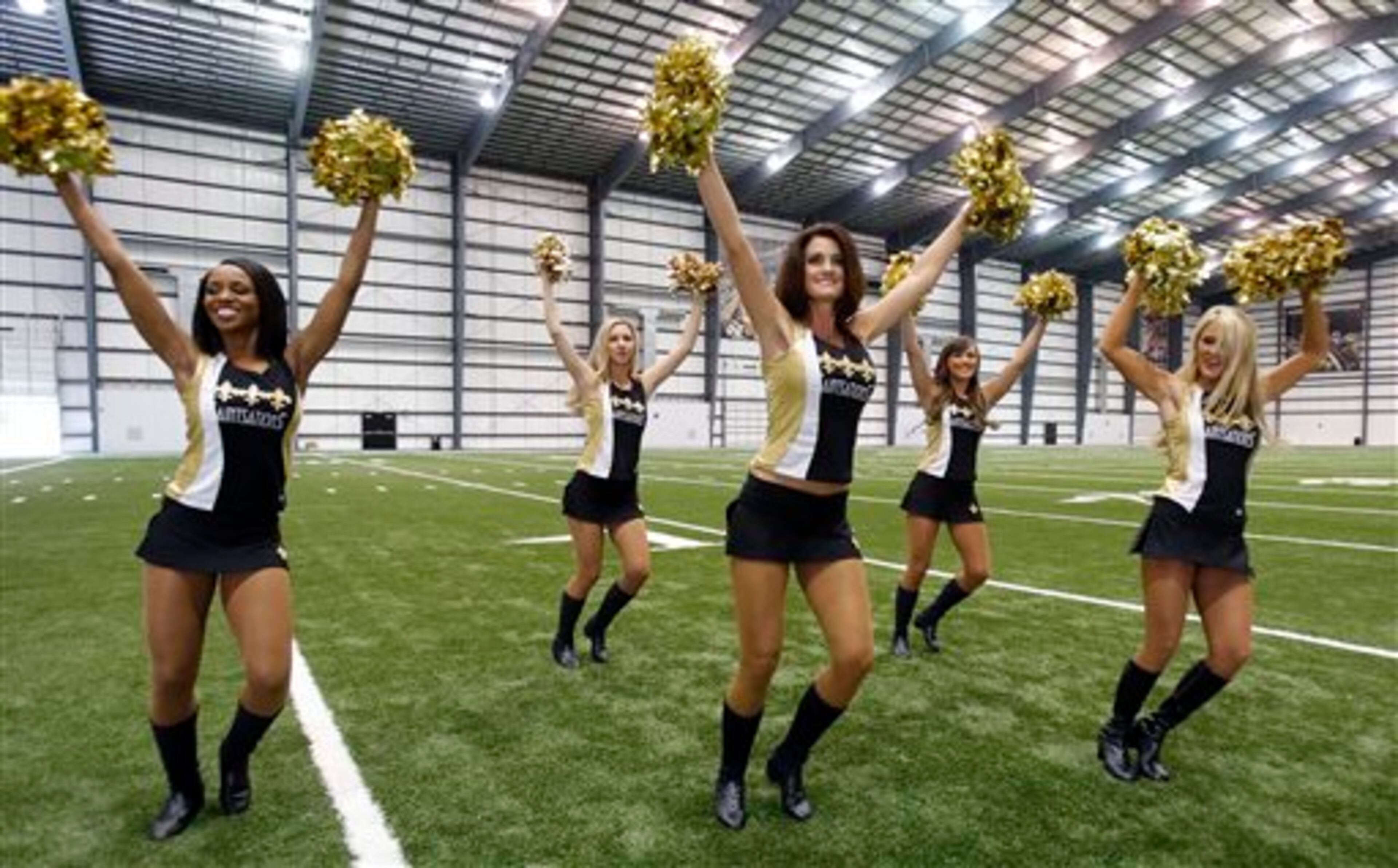 New Orleans Saints Saintsation Kriste Lewis, center, performs during a photo shoot at the NFL football team's training facility in Metairie, La., Wednesday, July 16, 2014. Lewis is one of only two NFL cheerleaders in her 40s. The other dancer is 45-year-old Laura Vikmanis, who has been with the Cincinnati Bengals dance team, the Ben-Gals, since making the squad at age 40. (AP Photo/Bill Haber)