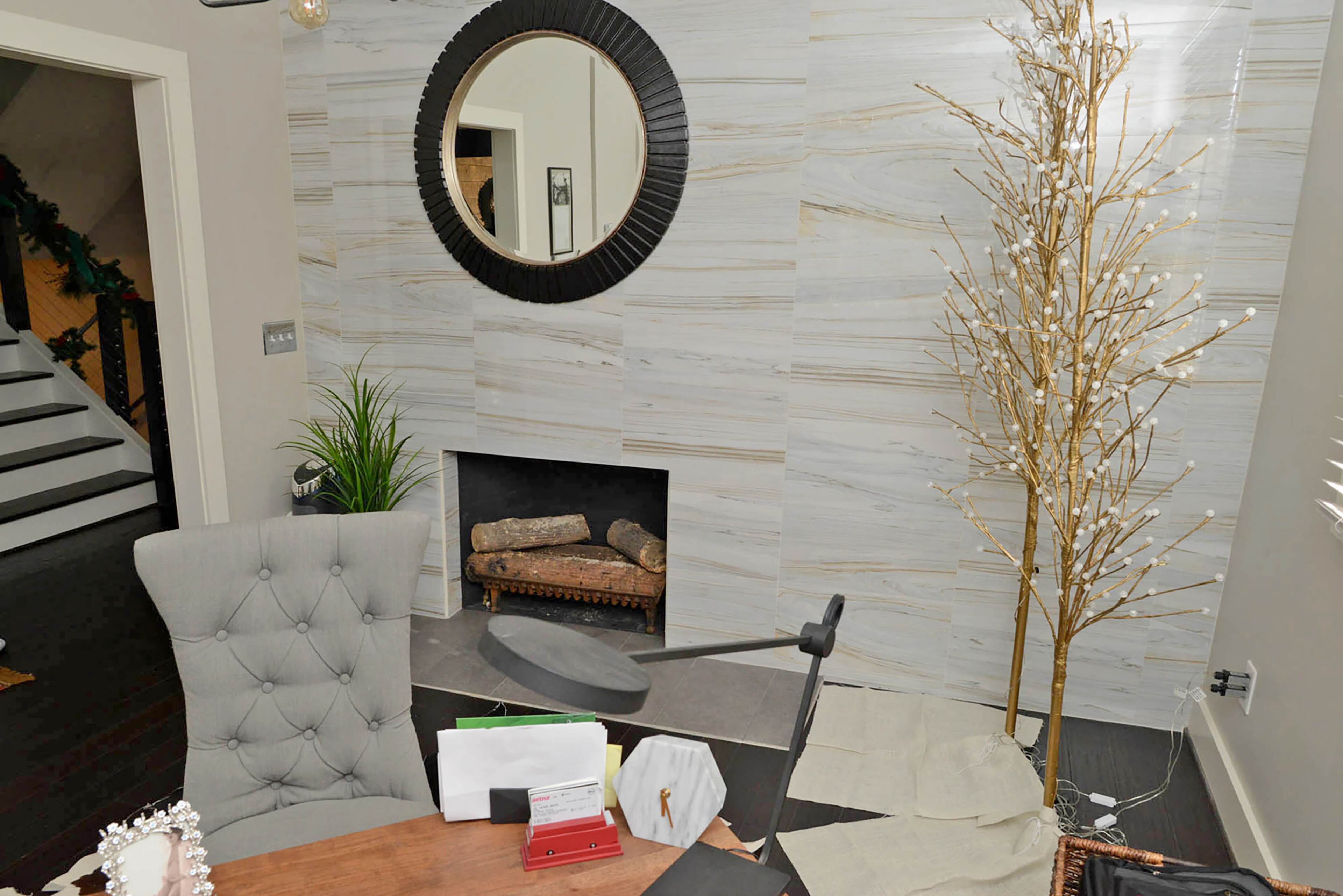 Floor-to-ceiling marble with gold veining surrounds the fireplace, and two gold LED holiday trees from RH infuse modern style into the home office, one of two in the Avondale Estates home.