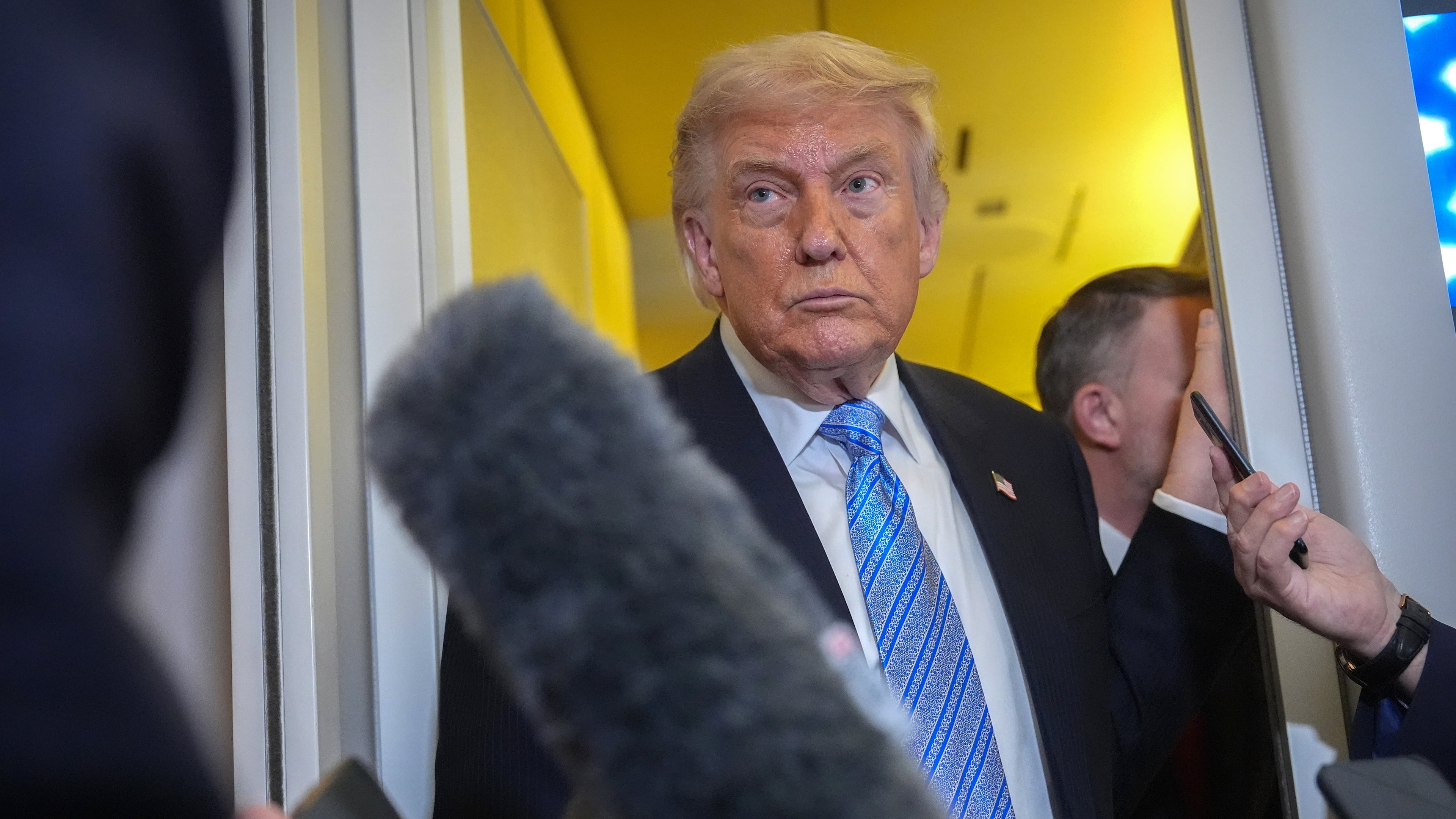 President Donald Trump speaks to reporters aboard Air Force One, Friday, May 15, 2026, as he returns from a trip to Beijing, China. (AP Photo/Mark Schiefelbein)
