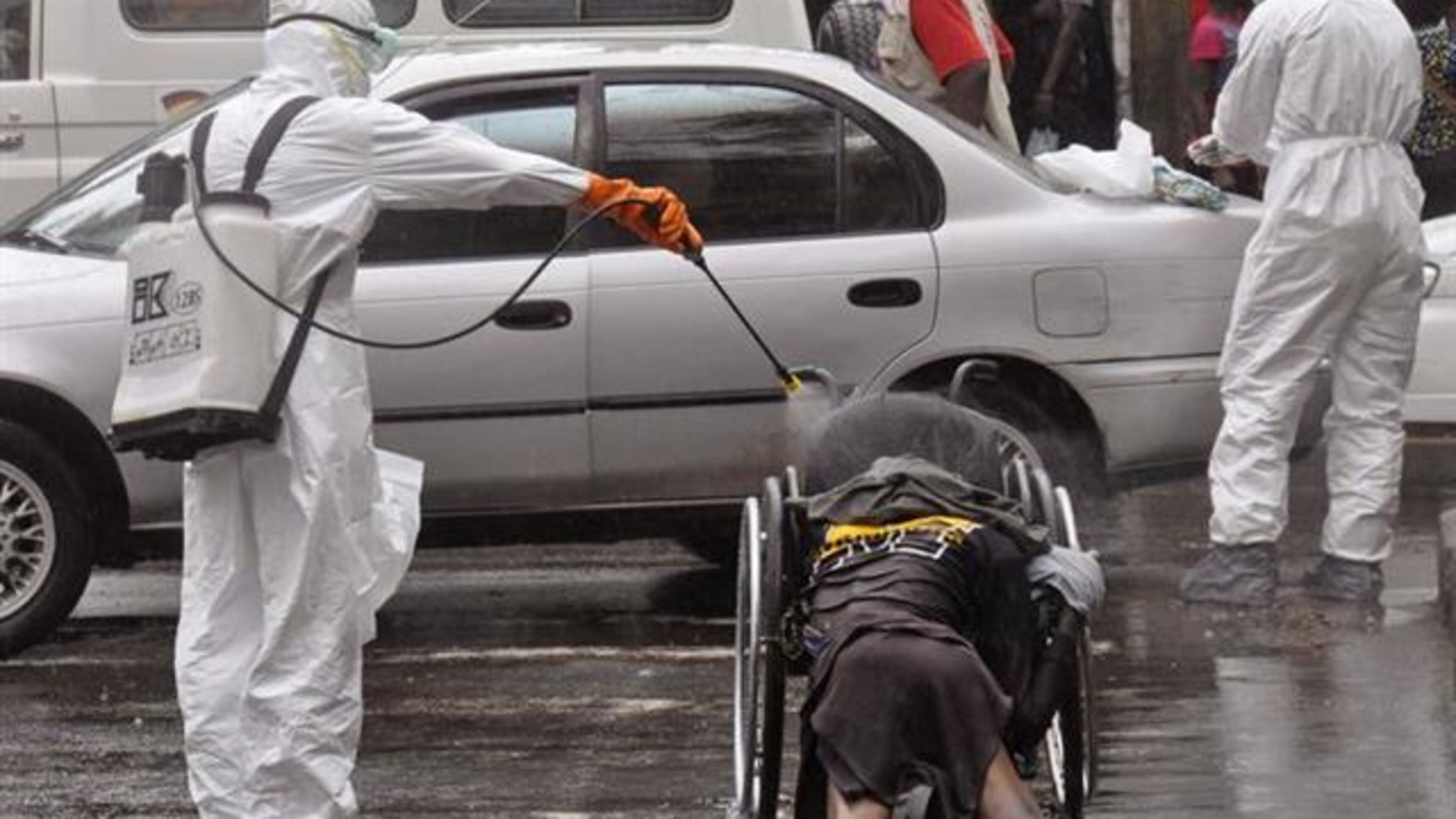 Health workers disinfect the body of a person suspected of dying from the Ebola virus on Sept. 2 in Monrovia, Liberia. (AP Photo)