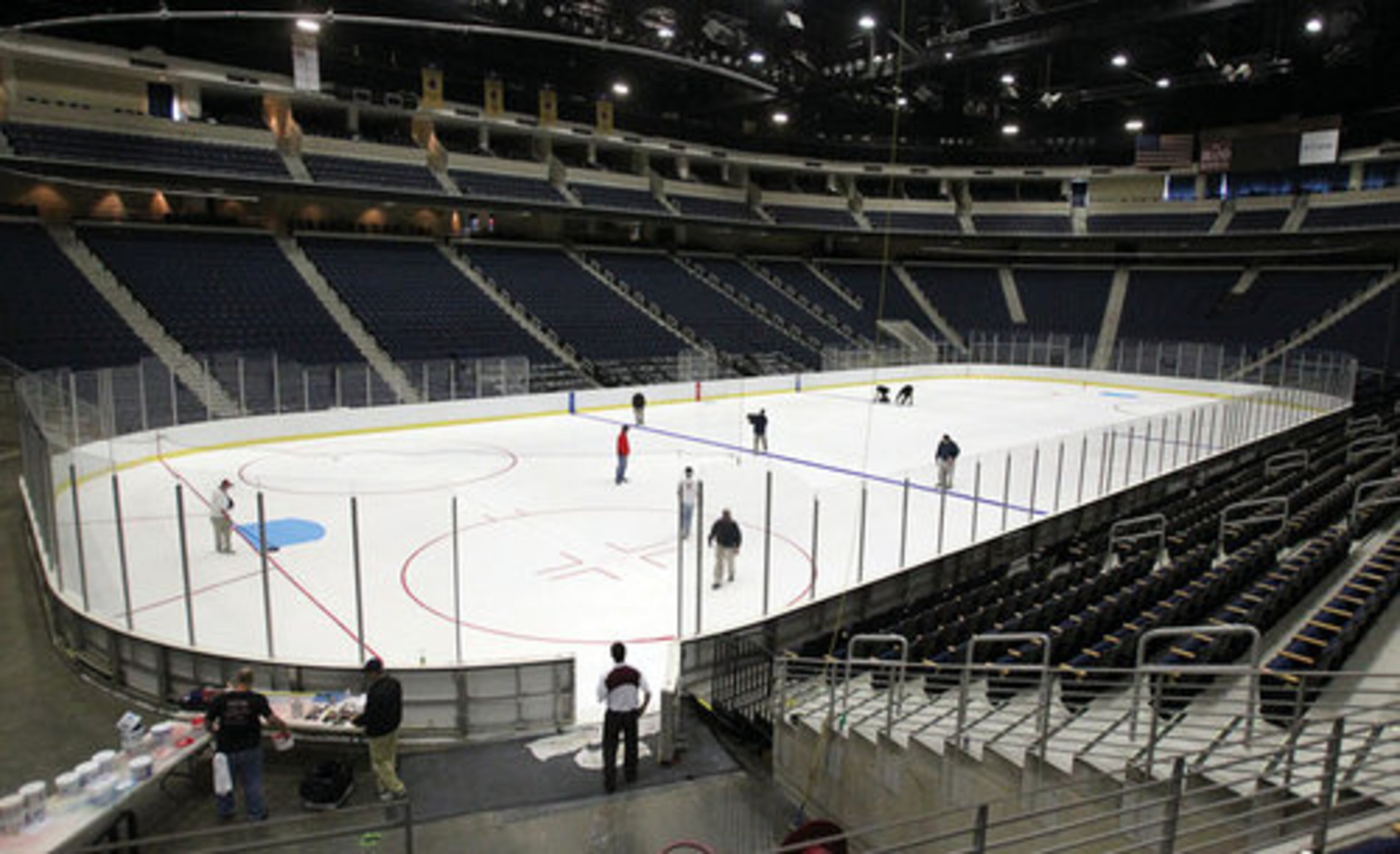The operations crew at the Arena at Gwinnett Center paint the lines and logos on the ice on Thursday, Oct. 13, 2011.