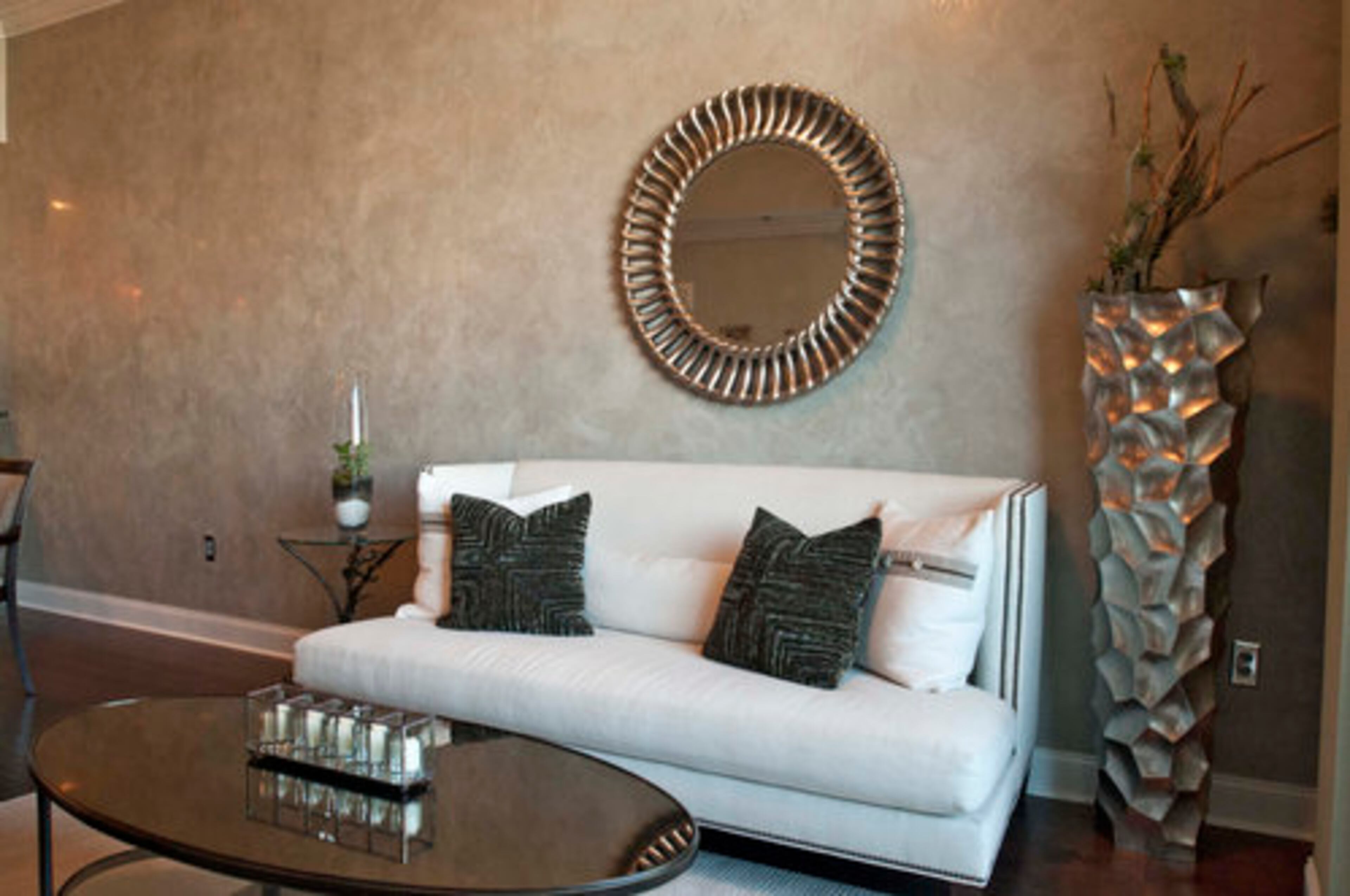 We wanted the white couch to balance the room. ... The mirror and vase add visual interest to the living room, Redmond said.