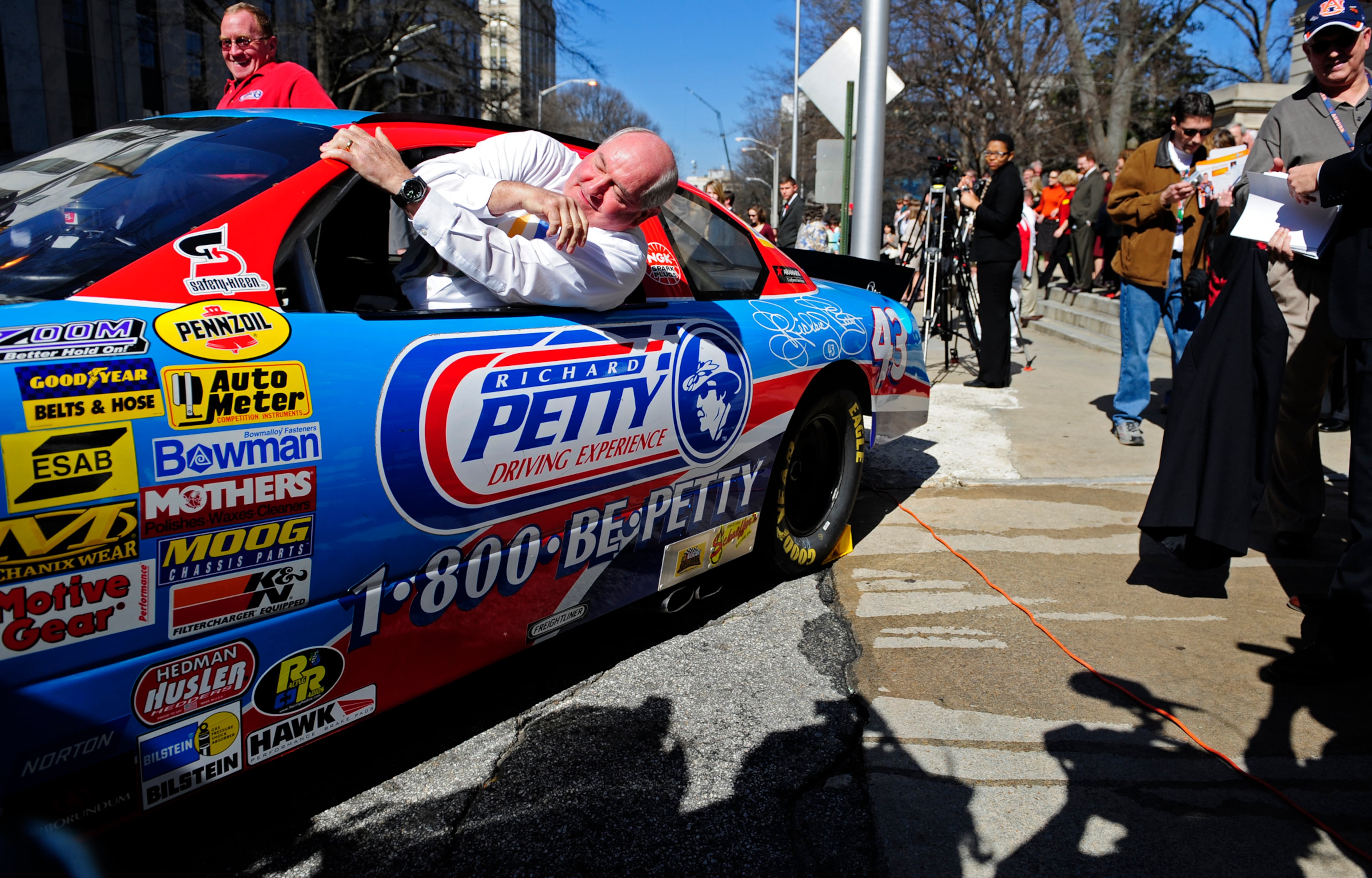 ATLANTA, GA: Gov. Sonny Perdue hops into a Richard Petty Driving Experience car surrounded by the media outside the Capitol Thursday, March 6, 2008 to take a spin around the block for Atlanta Motor Speedway Day. Elissa Eubanks/AJC