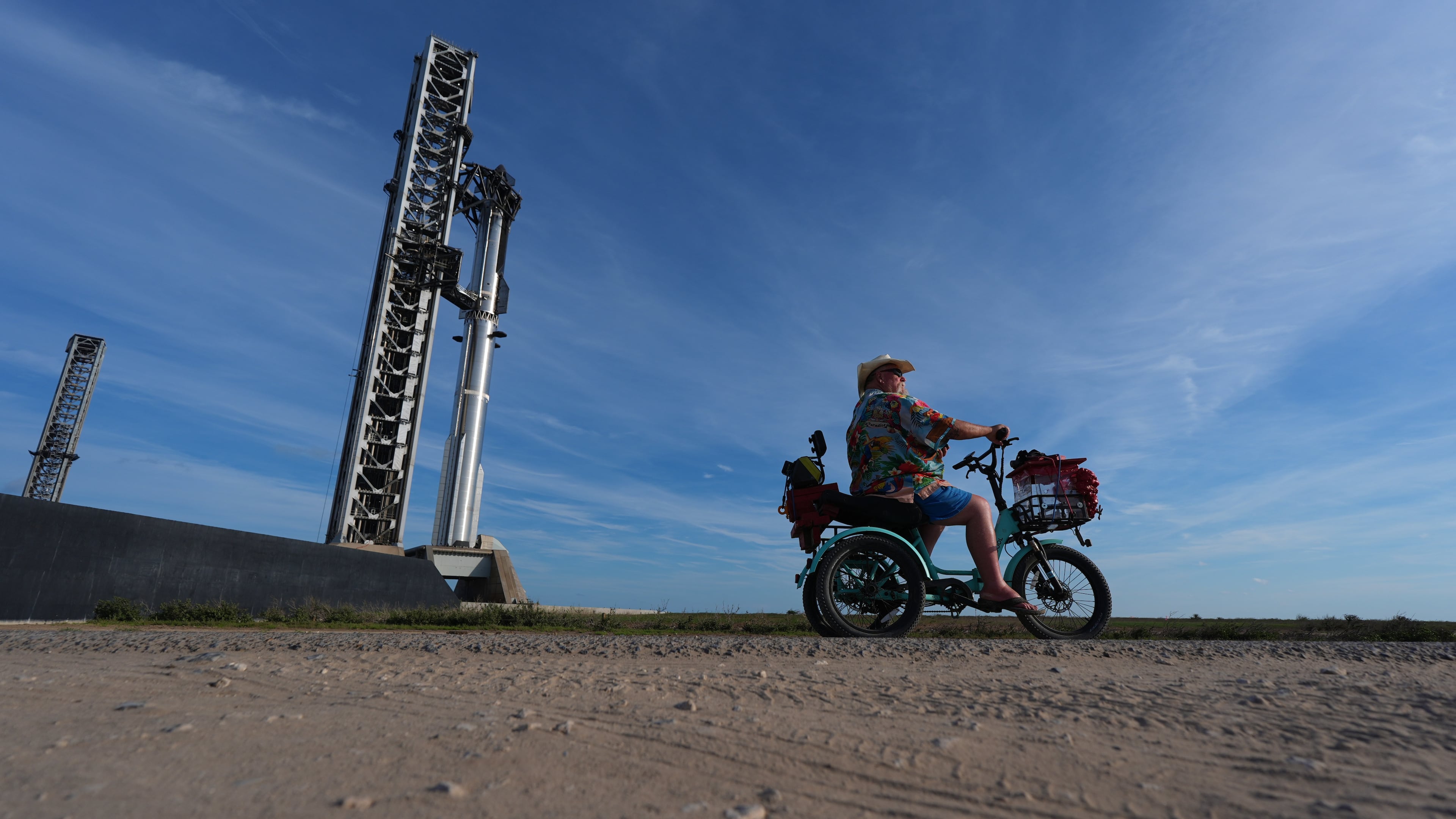 David Orr rides his bike past SpaceX's mega rocket Starship as it is prepared for a test flight from Starbase, Texas, Sunday, Sept. 27, 2026. (AP Photo/Eric Gay)
