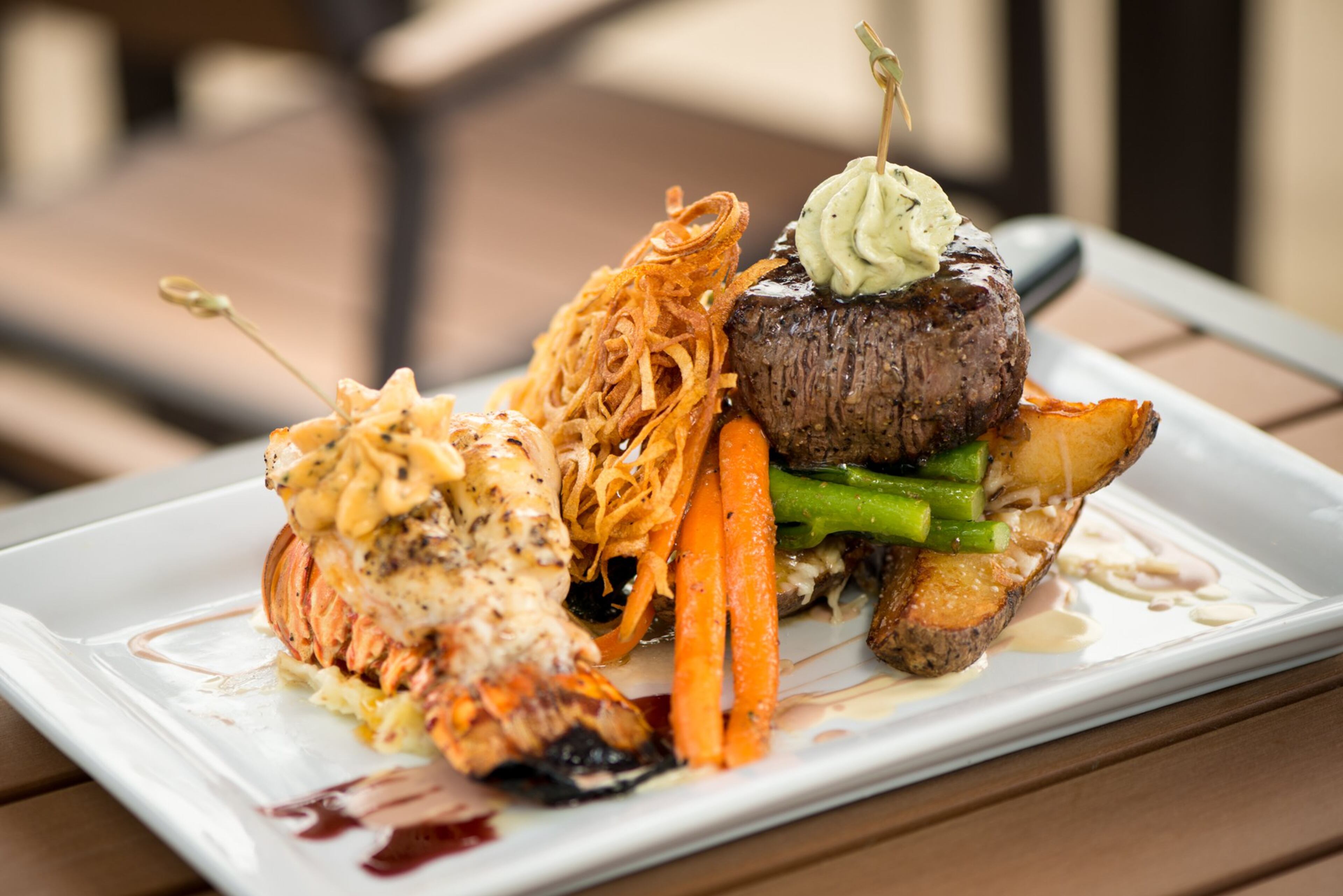 A Sage Woodfire Tavern classic is Surf & Turf with black angus petite filet, Maine lobster tail, hand cut steak fries, spinach, and lobster butter. Photo credit- Mia Yakel.