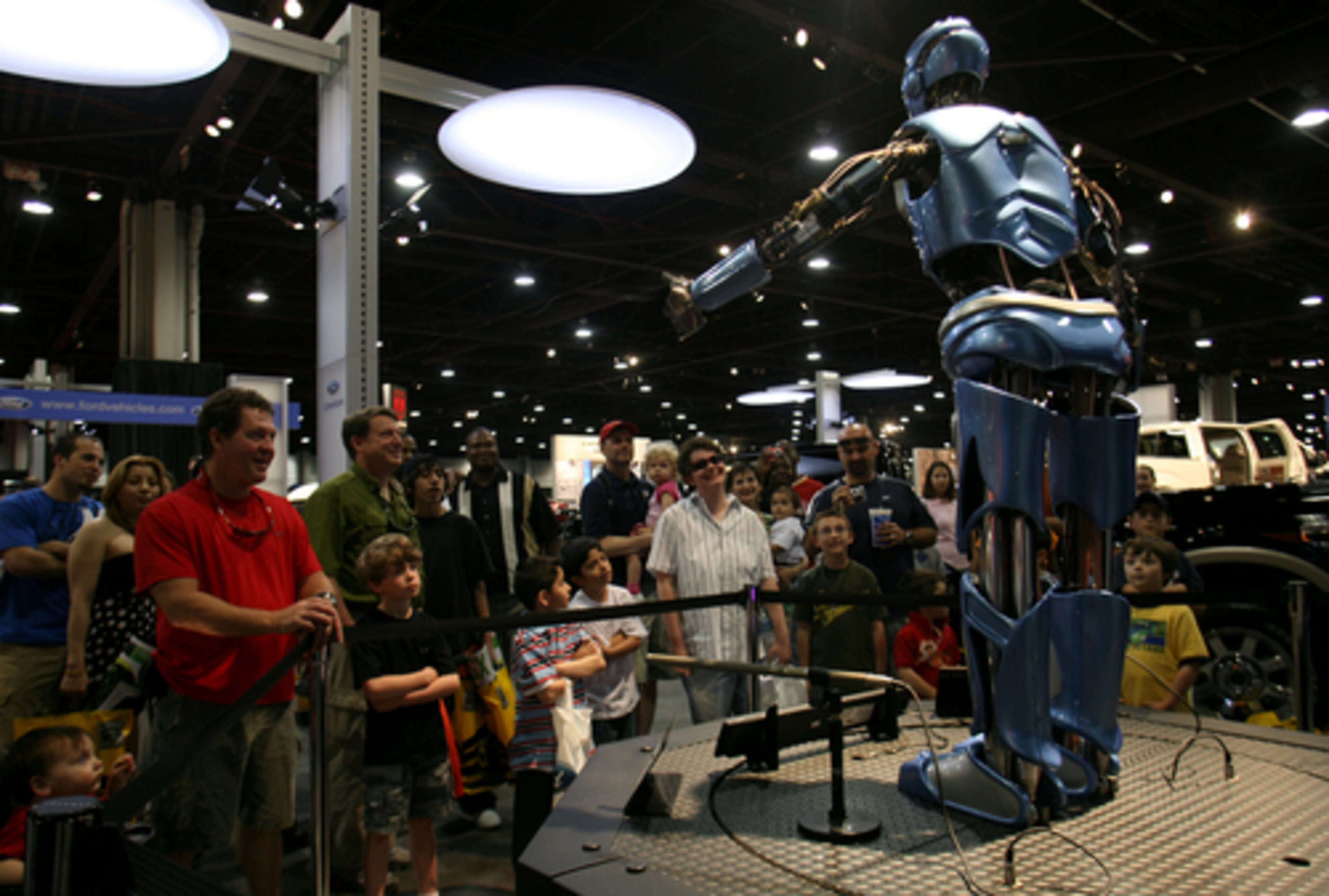 An audience gathers around MAX, an interactive robot for Ford, during the AJC International Car Show at the Georgia World Congress Center on Sunday. The robot, which has the ability to talk, ask and answer audience questions, helps promote Ford's "Innovation First" slogan.