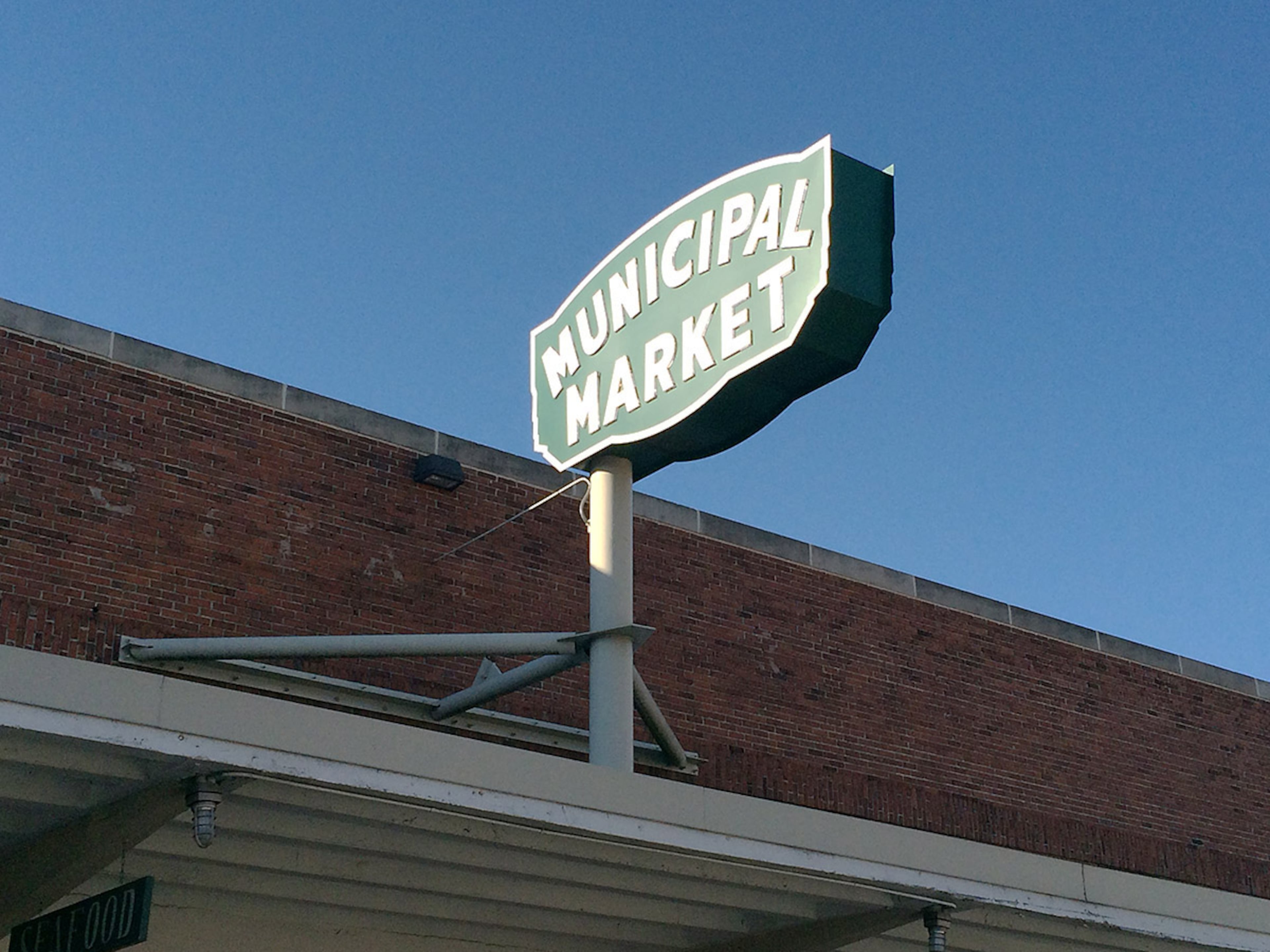 The original "Municipal Market" sign had been kept in back storage until 2011, when it got refurbished and reinstalled to its current location in the center of the market (see earlier photo). A similar, non-neon version of the "Municipal Market" sign is now posted over the Edgewood Avenue entrance, as part of the restoration to its historic condition. Look closely at the bricks, and you'll see a ghost sign for the word "Municipal." (PETE CORSON / pcorson@ajc.com)