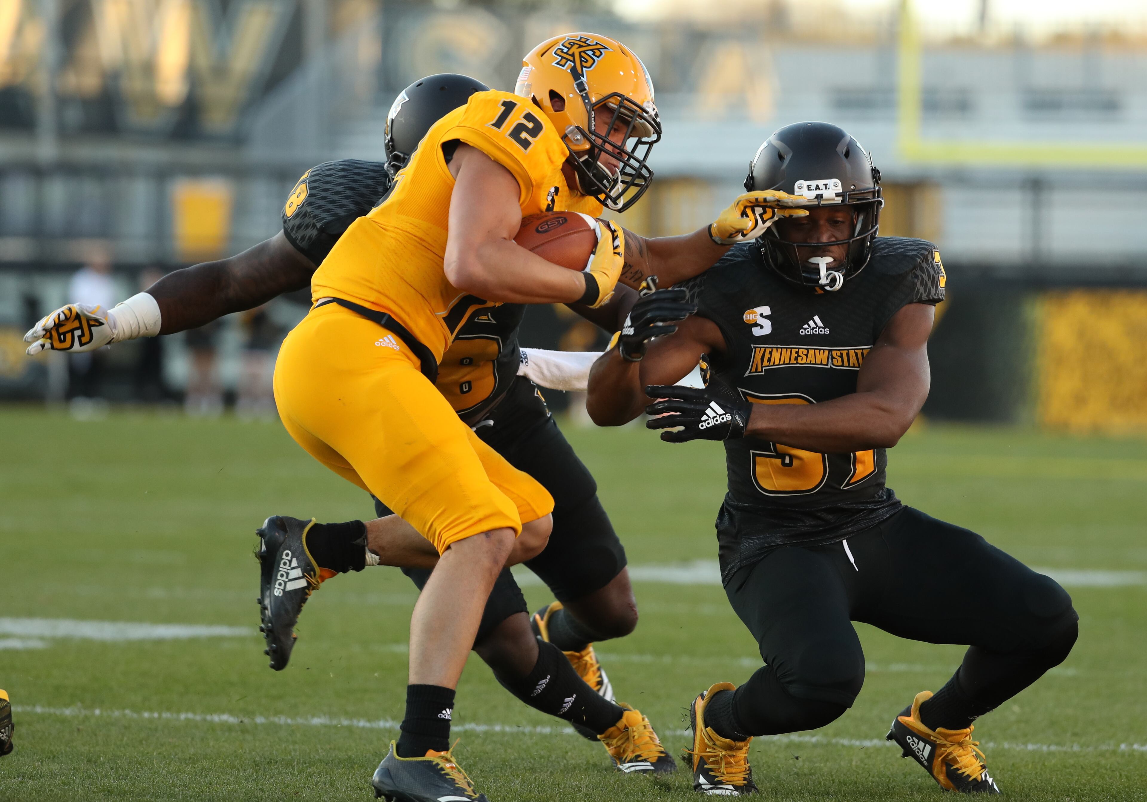 March 22, 2019 - Kennesaw, Ga: Kennesaw State Owls running back Isaac Foster (12) is tackled by linebacker Kareem Taylor (48) and defensive back Adesola Abisoye (31) during the KSU spring football game at Fifth Third Bank Stadium Friday, March 22, 2019 in Kennesaw, Ga.. (JASON GETZ/SPECIAL TO THE AJC)