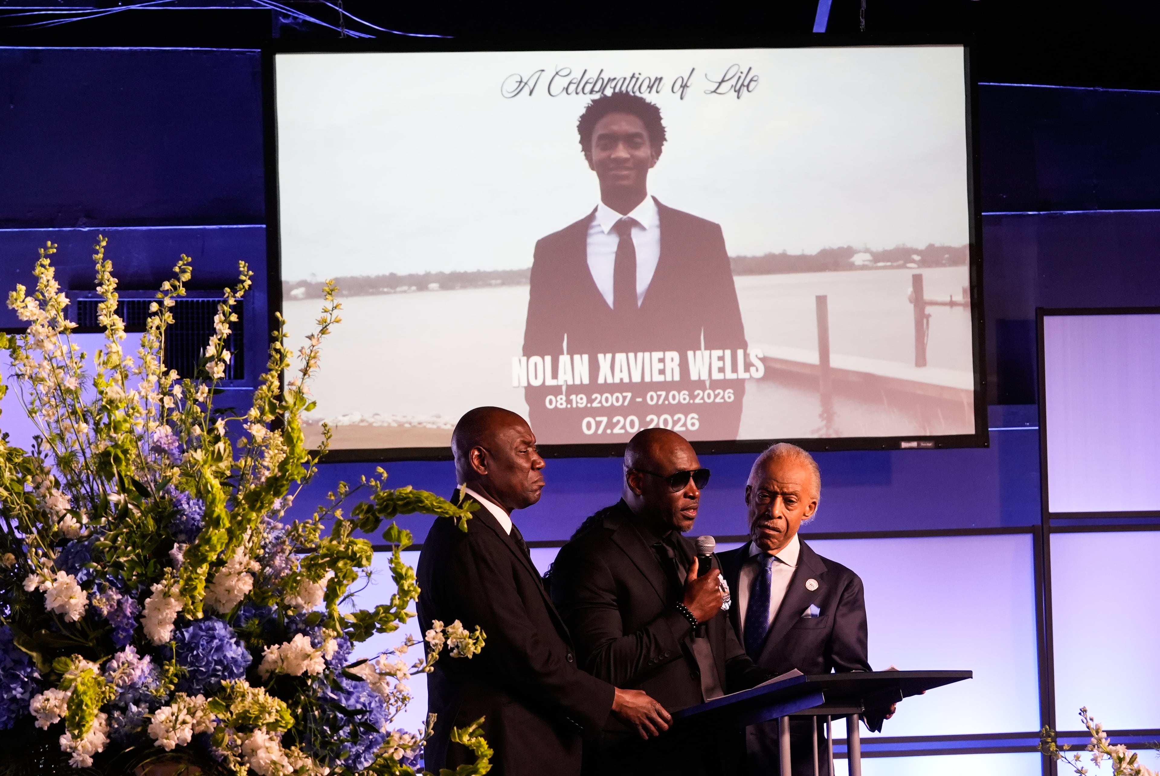Elmore Wonsley (center) speaks next to attorney Ben Crump (left) and the Rev. Al Sharpton during a memorial service Monday, July 20, 2026, in Ocean Springs, Miss., for Nolan Xavier Wells, an 18-year-old found dead after taking a July 4 boat trip with friends. (Gerald Herbert/AP)