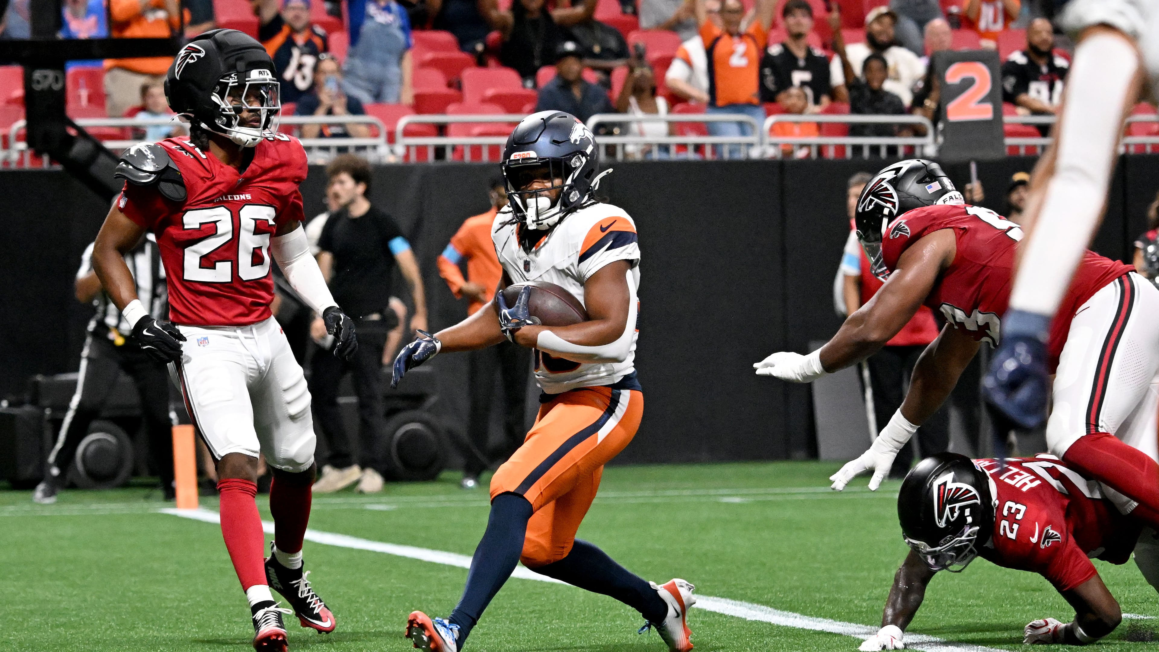 Broncos running back Jaleel McLaughlin (center) scores a touchdown against the Falcons during their exhibition game at Mercedes-Benz Stadium on Friday, Aug. 14, 2026, in Atlanta. By halftime, the Broncos had run 17 times for 94 yards. (Hyosub Shin/AJC)