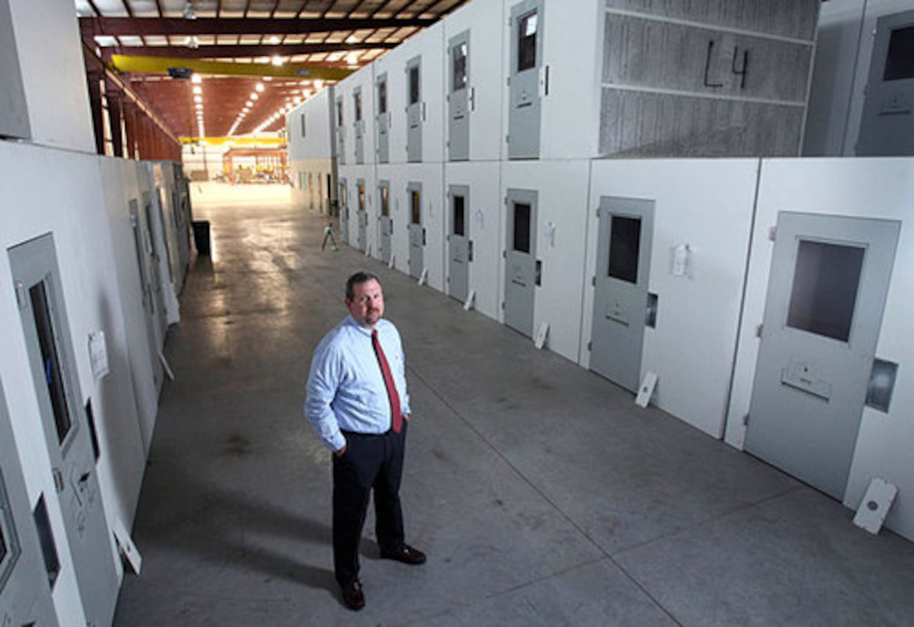 Steel Cell President and CEO Mike Smith stands next to 95 finished cells that are ready to be shipped for the Douglas County Jail in Minnesota shown at his plant Wednesday.