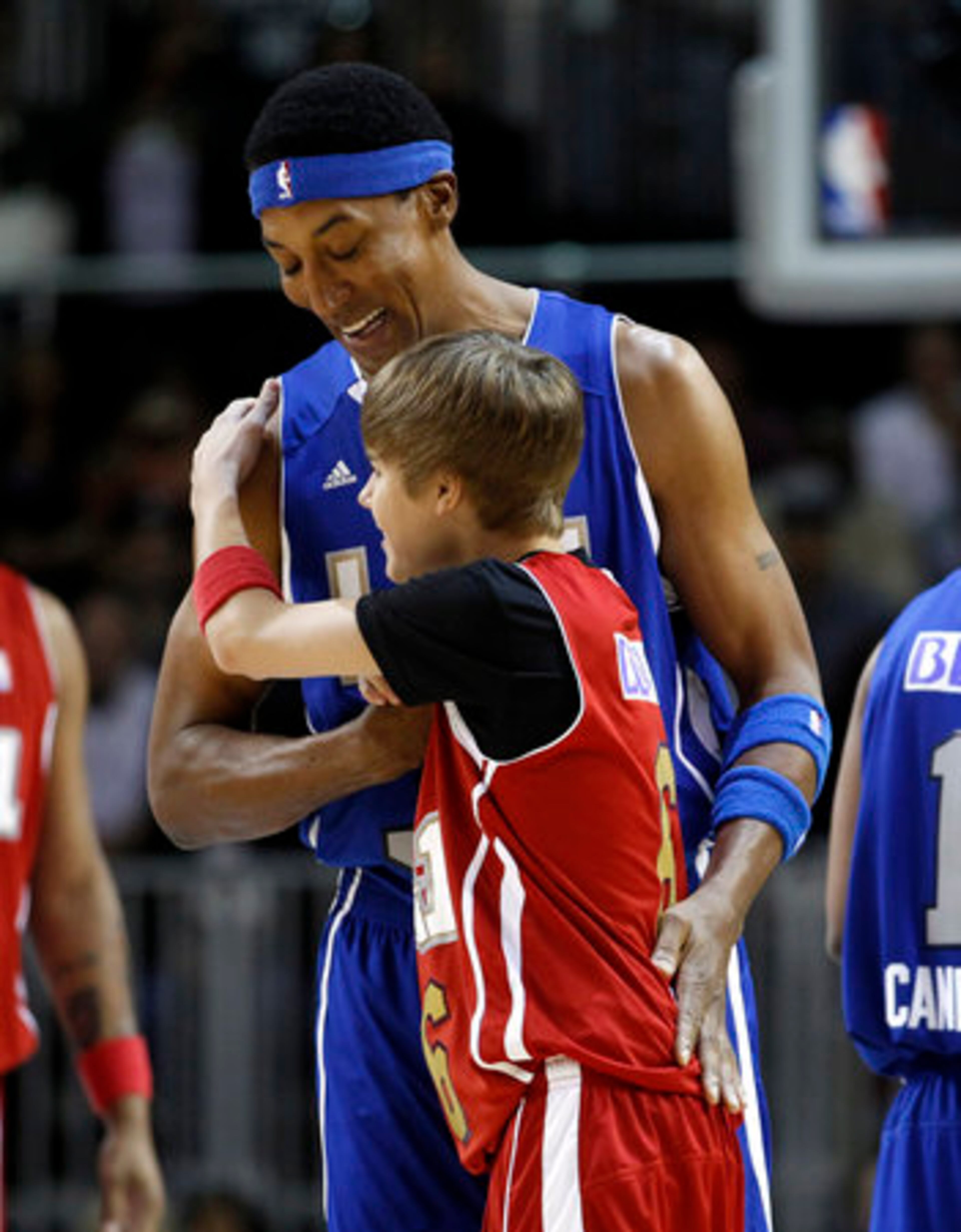 Former NBA basketball player Scottie Pippen, top, hugs Justin Bieber during a BBVA All-Star celebrity basketball game at the NBA All Star Weekend in Los Angeles.