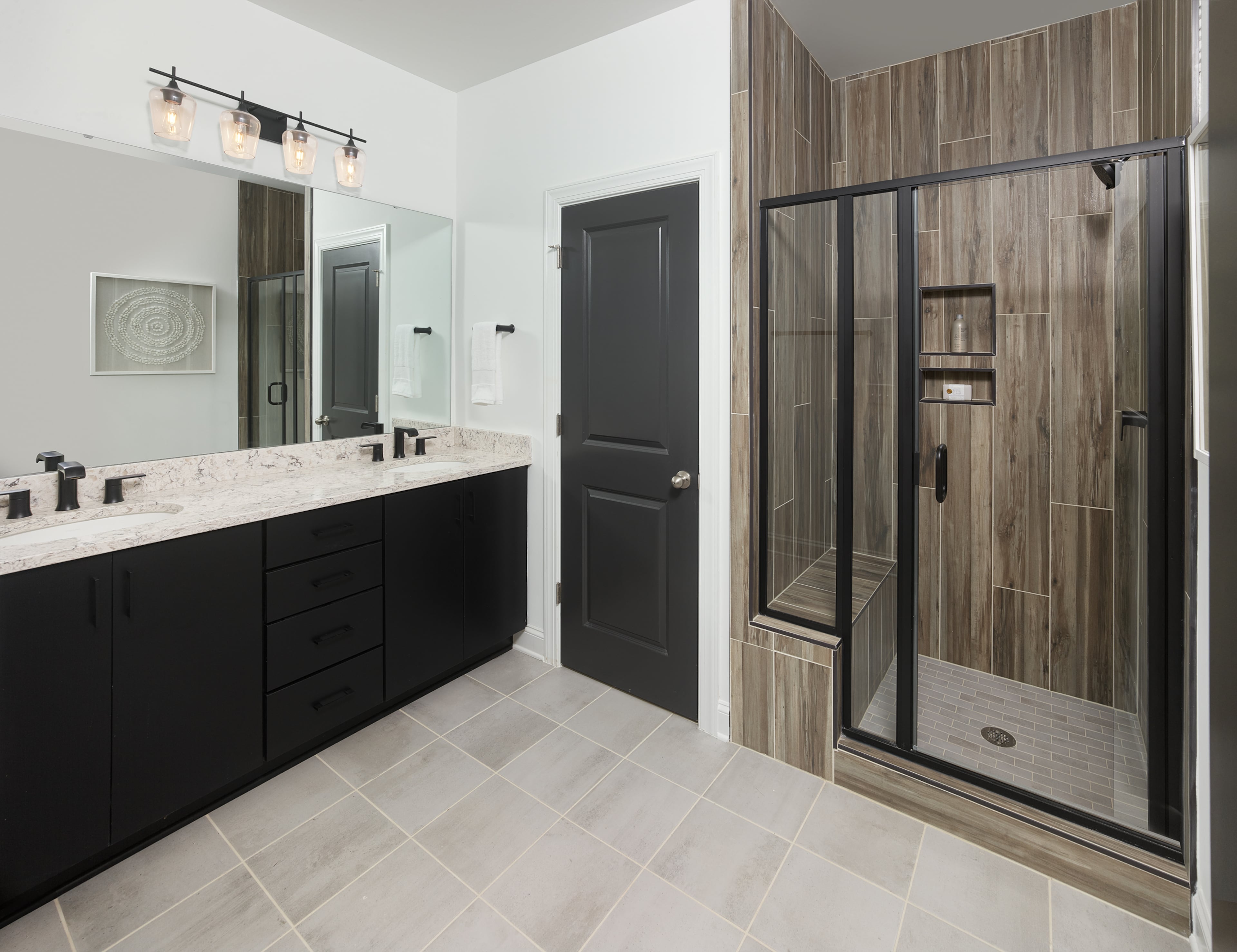 Dark tones and natural elements in owner’s bath in Ellwood model in Ashton Woods community in Raleigh, NC.