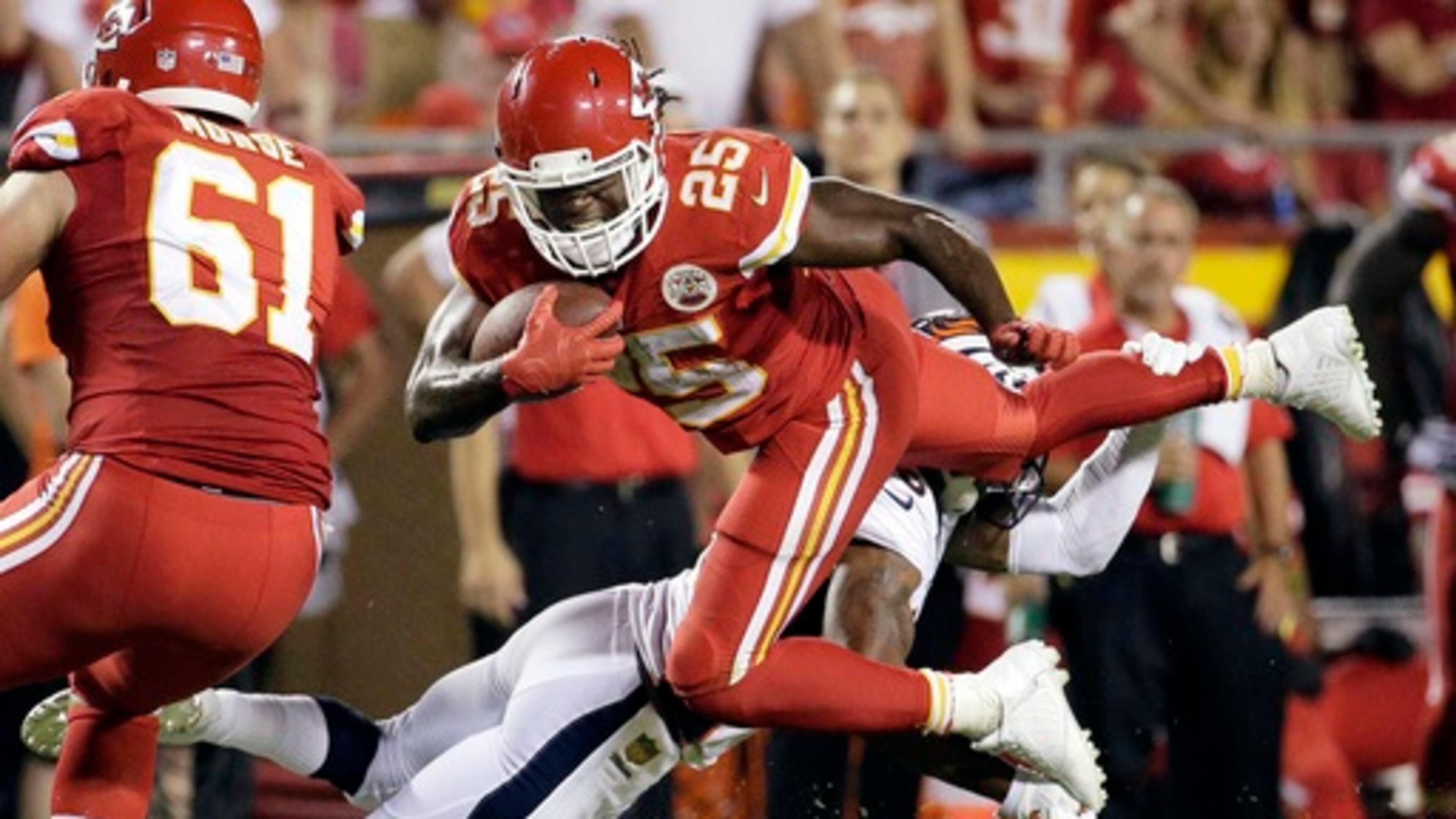 In this Sept. 17, 2015, file photo, Kansas City Chiefs running back Jamaal Charles (25) is tackled by Denver Broncos cornerback Chris Harris Jr., rear, during the second half of an NFL football game in Kansas City, Mo. Adrian Peterson and Jamaal Charles, both stalwarts for their previous clubs and with All-Pro credentials, are out there. But how many 30-plus running backs get long-term deals, even proven ones such as these? And both will want big bucks. (AP Photo/Charlie Riedel, File)